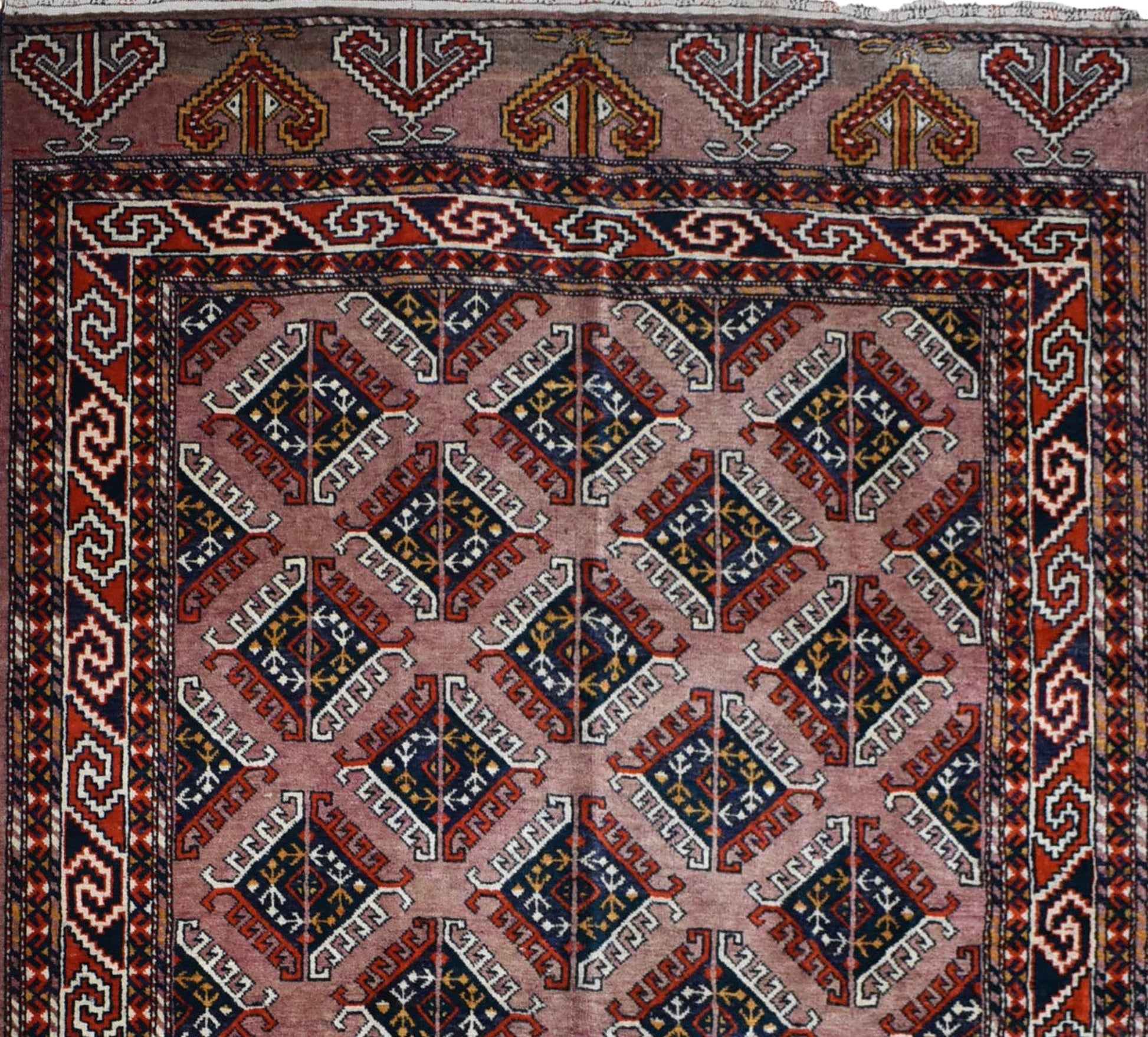 A vintage handmade Uzbek Bokhara wool rug featuring a repeating geometric diamond pattern in red and blue.