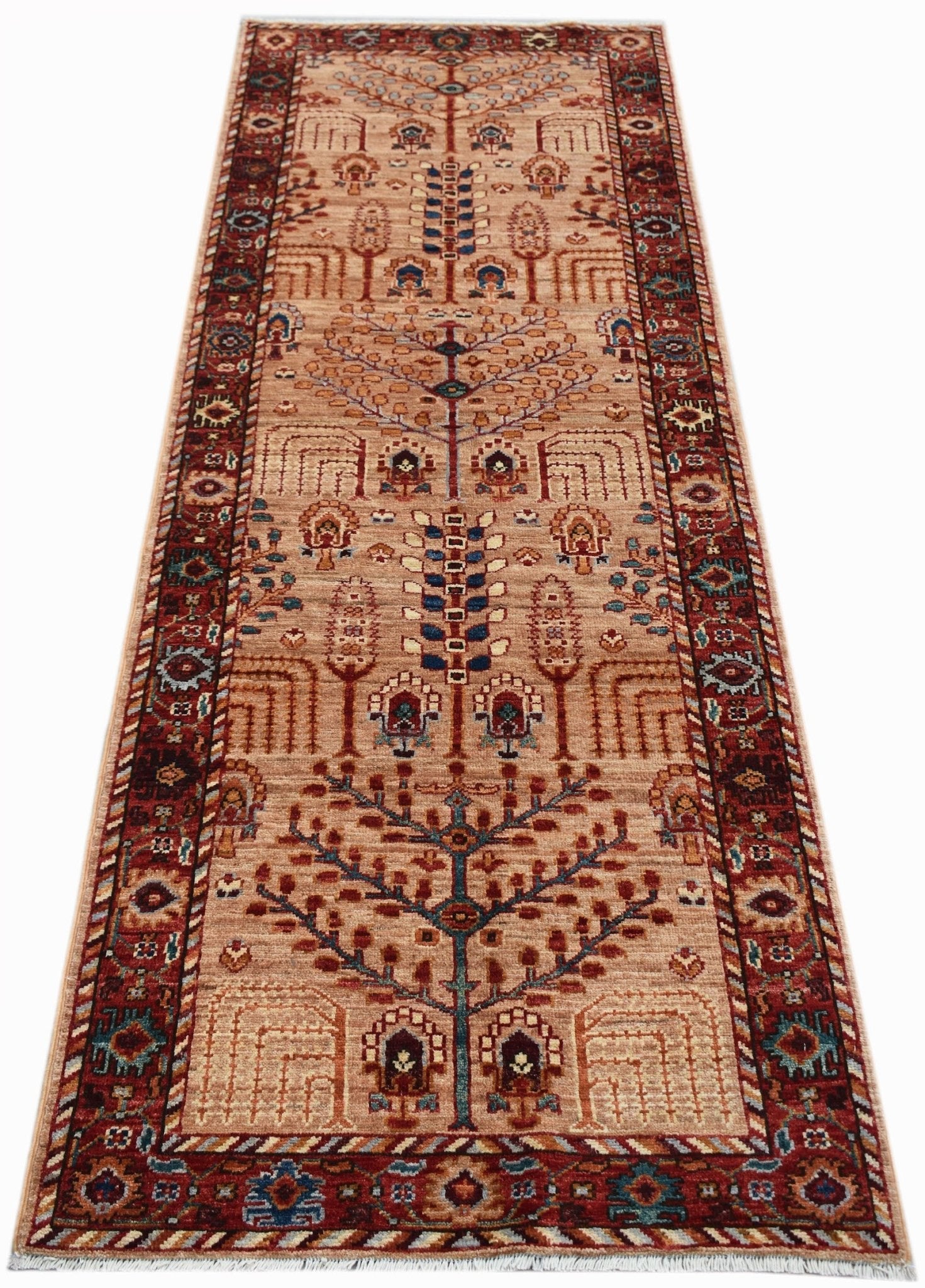 A handmade Afghan Chobi runner rug featuring a traditional Tree of Life pattern in earthy tones.