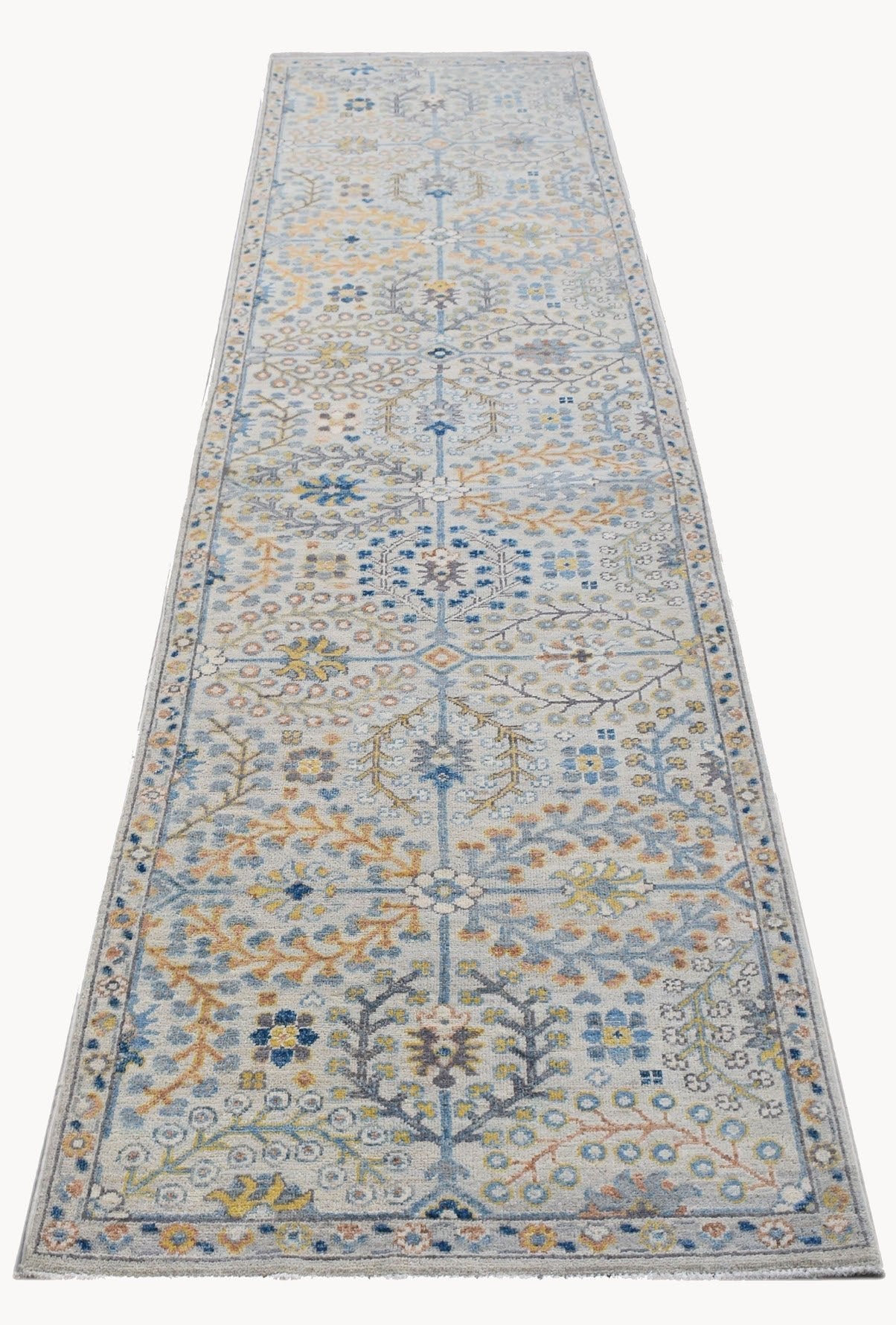 An Afghan Chobi runner rug featuring a traditional floral pattern in blue, yellow, and grey tones.