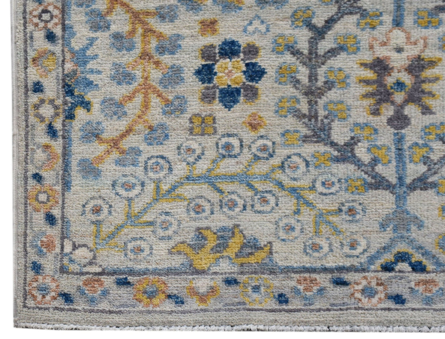 A handmade Afghan Chobi runner featuring a traditional floral pattern in blue, yellow, and grey.