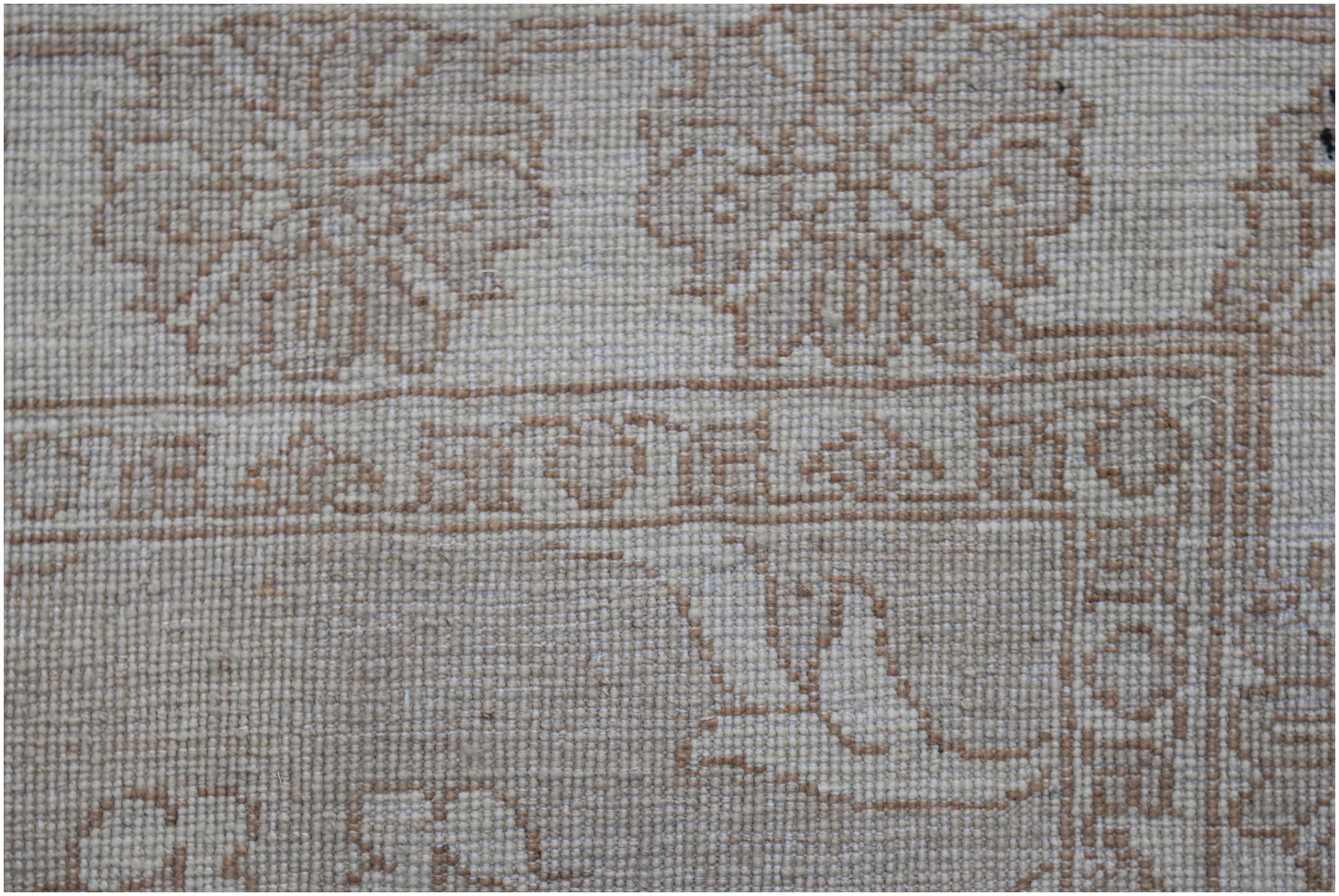 A close-up of an Afghan Chobi runner featuring intricate, light brown floral patterns on wool.
