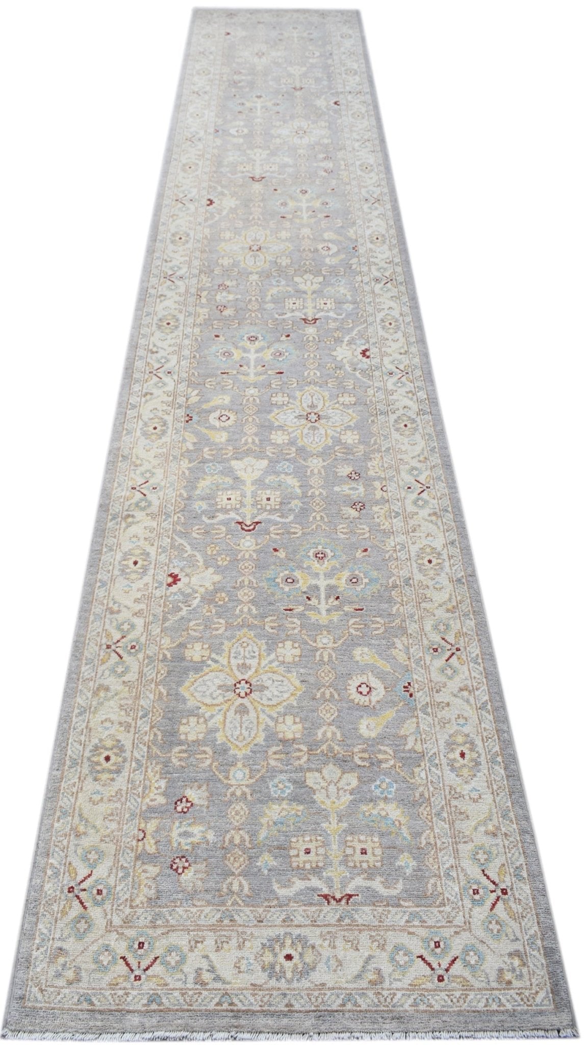 A handwoven Afghan Chobi runner rug featuring a traditional floral pattern in soft neutral tones.