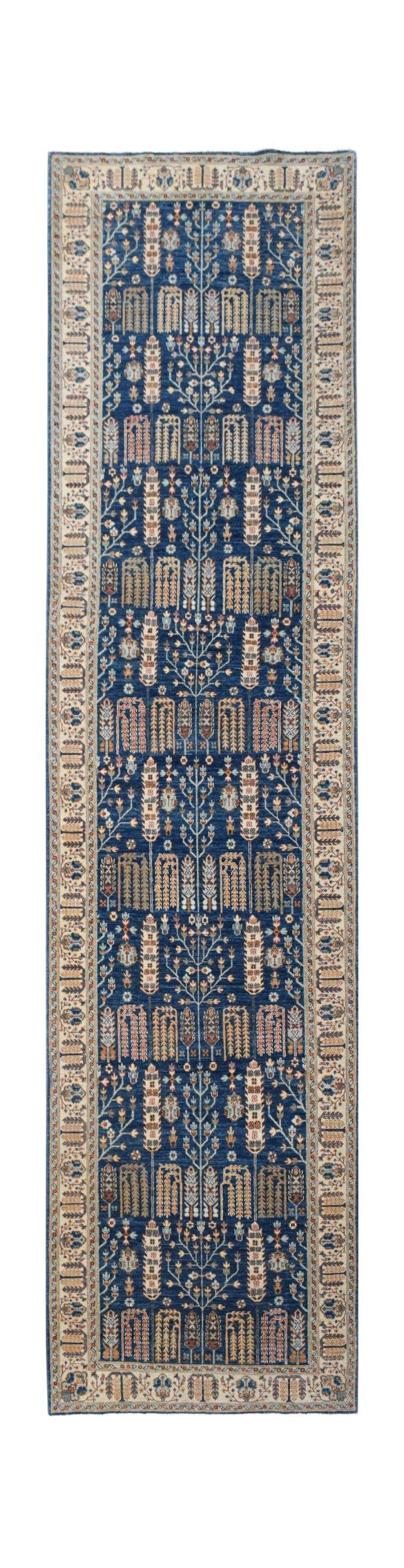 A handwoven Afghan Chobi runner featuring a blue field with a repeating tree of life pattern.