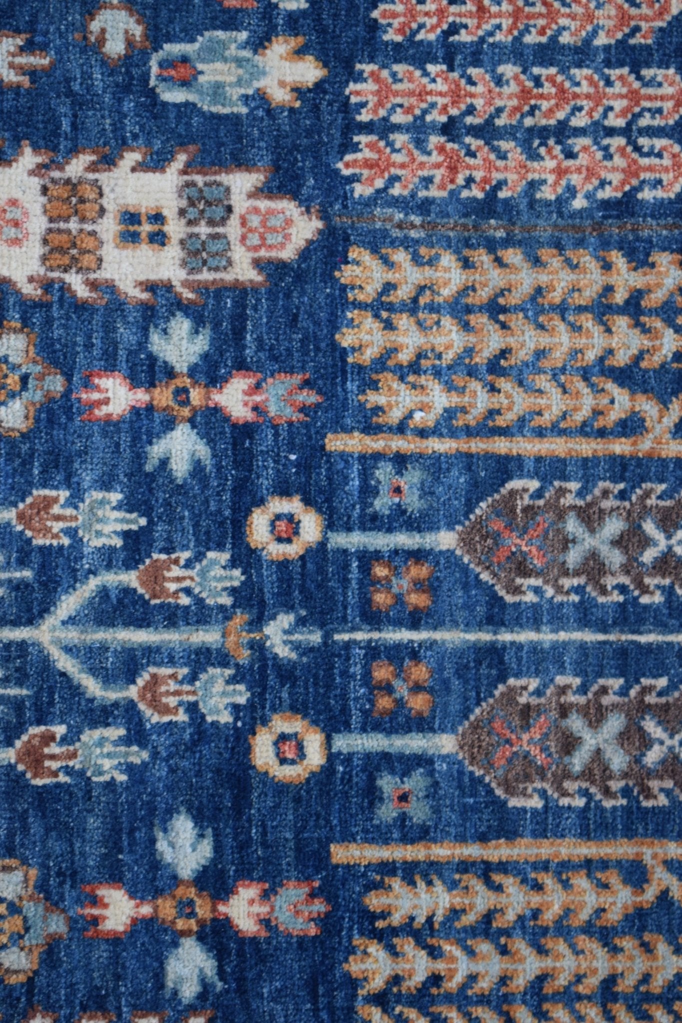 A handwoven Afghan Chobi runner featuring a traditional blue field with intricate tree of life motifs.