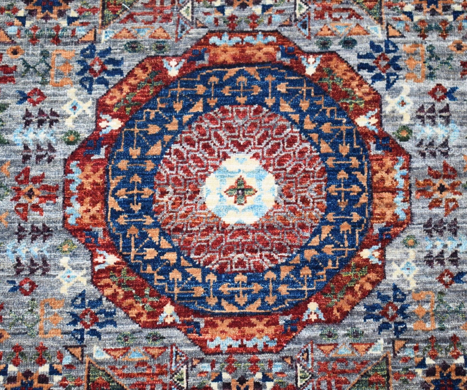 A handmade Afghan Chobi runner featuring a detailed Mamluk medallion in red and blue tones.