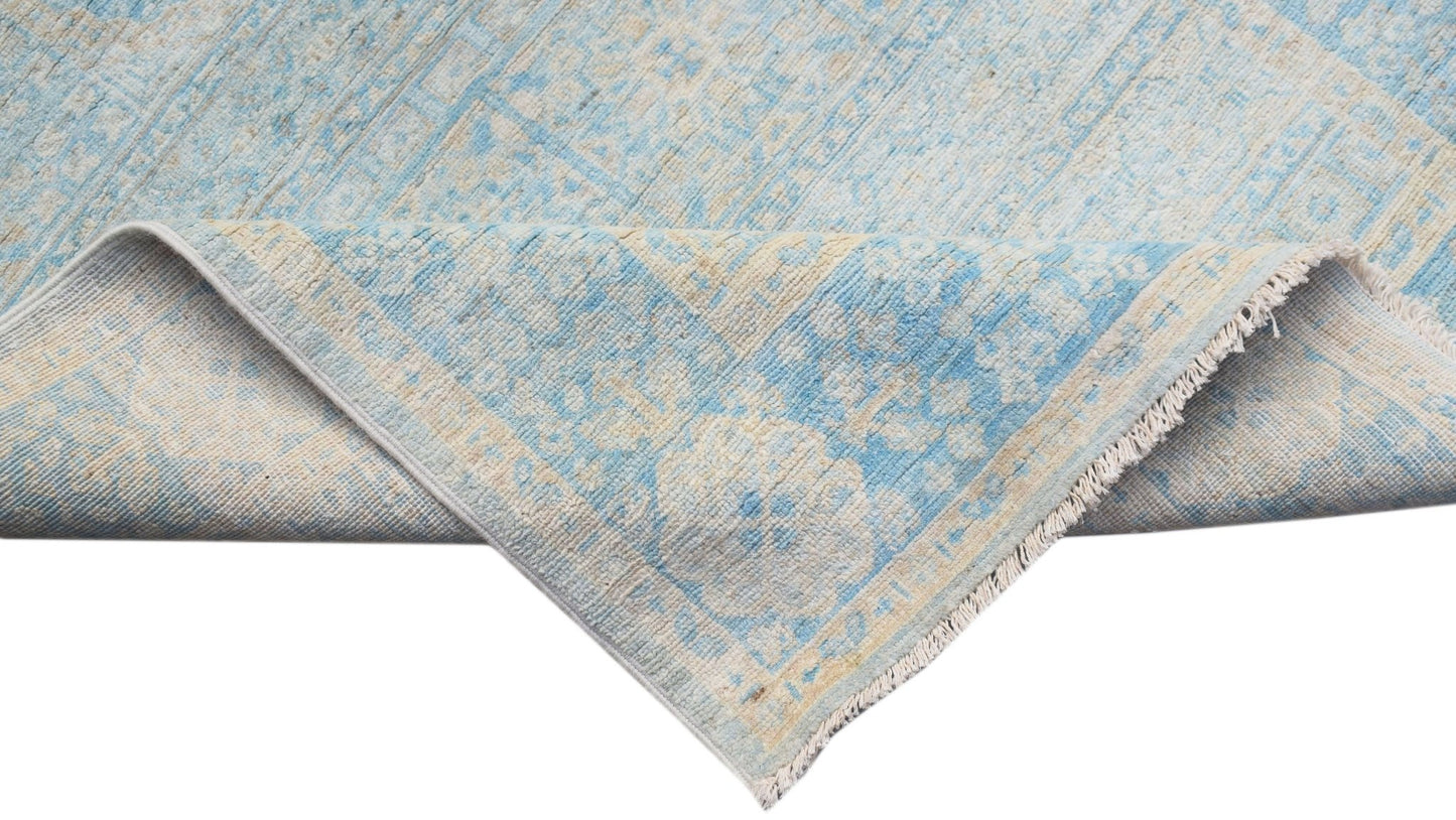 A handwoven Afghan Chobi runner featuring a light blue and cream Mamluk medallion pattern.