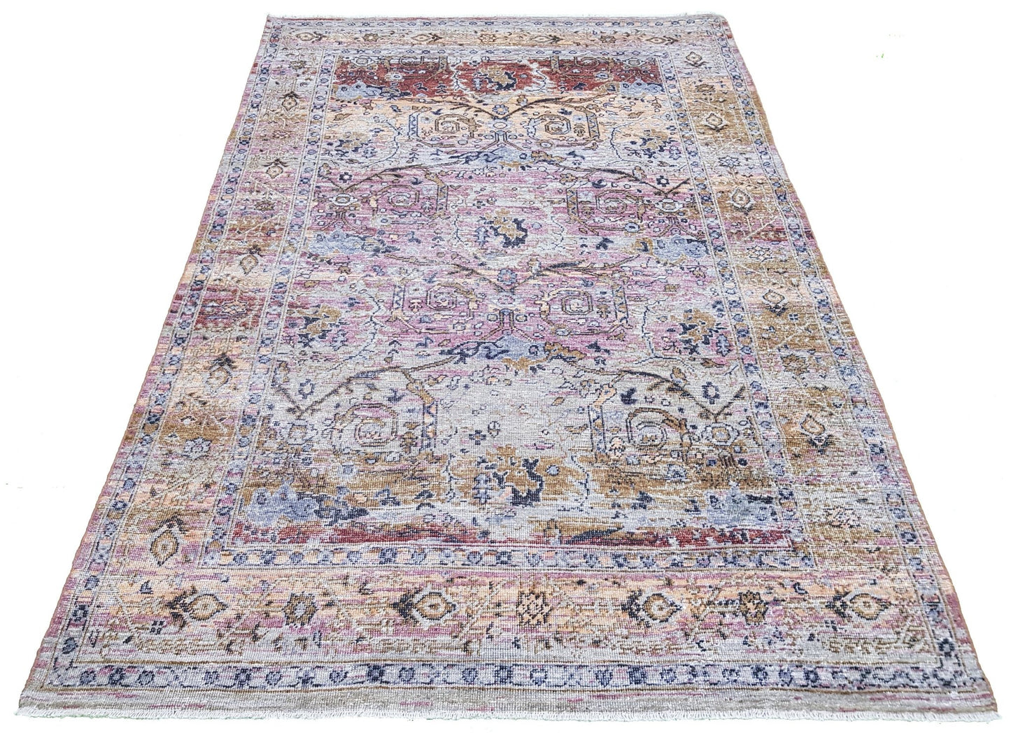 A rectangular transitional Oushak rug featuring a distressed pattern in muted pink, blue, and tan.