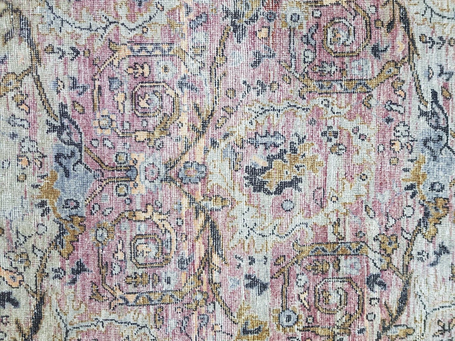A transitional Oushak rug featuring a vintage-inspired floral pattern in muted pink and gold tones.