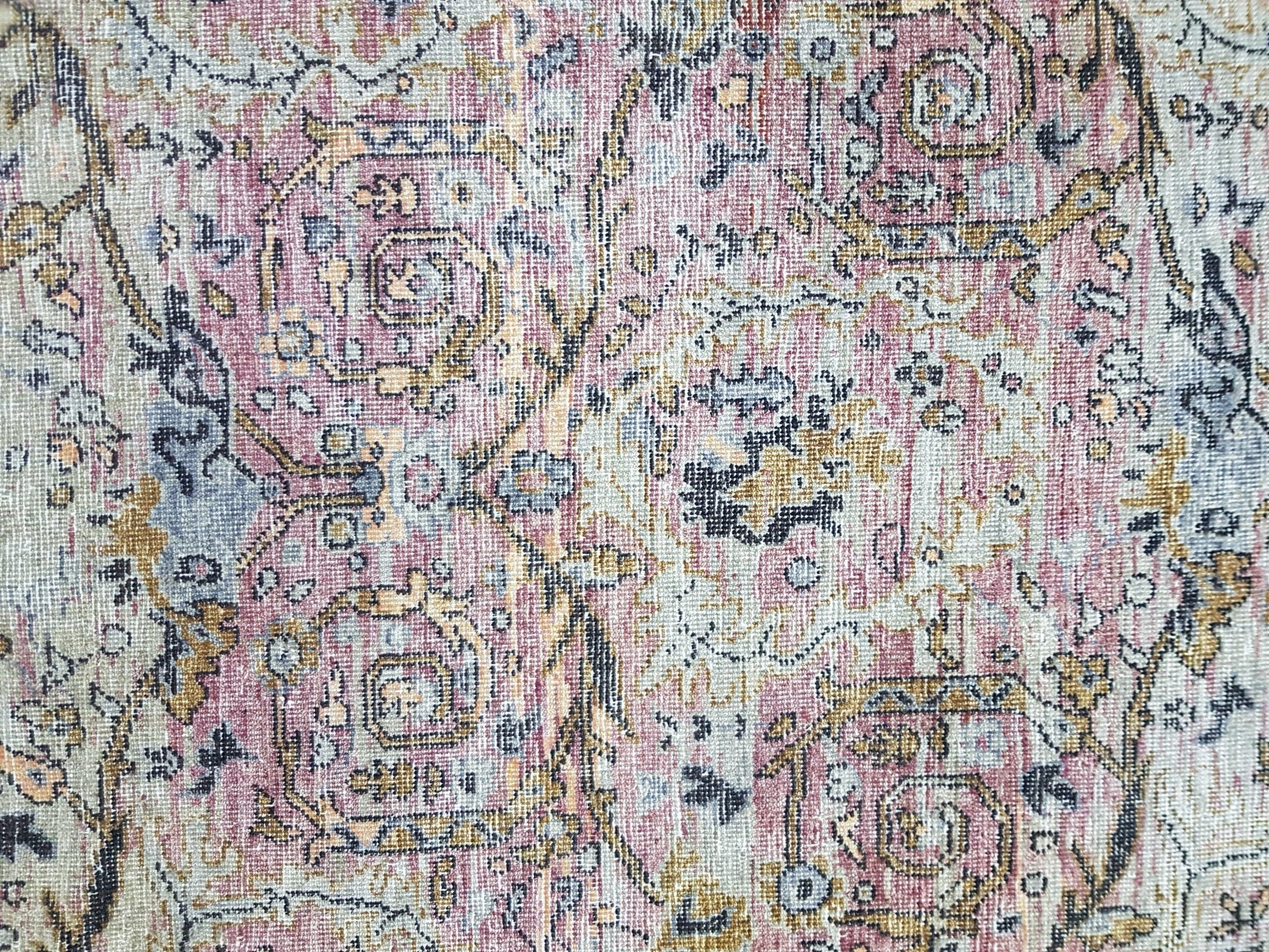 A transitional Oushak rug featuring a vintage-inspired floral pattern in muted pink and gold tones.