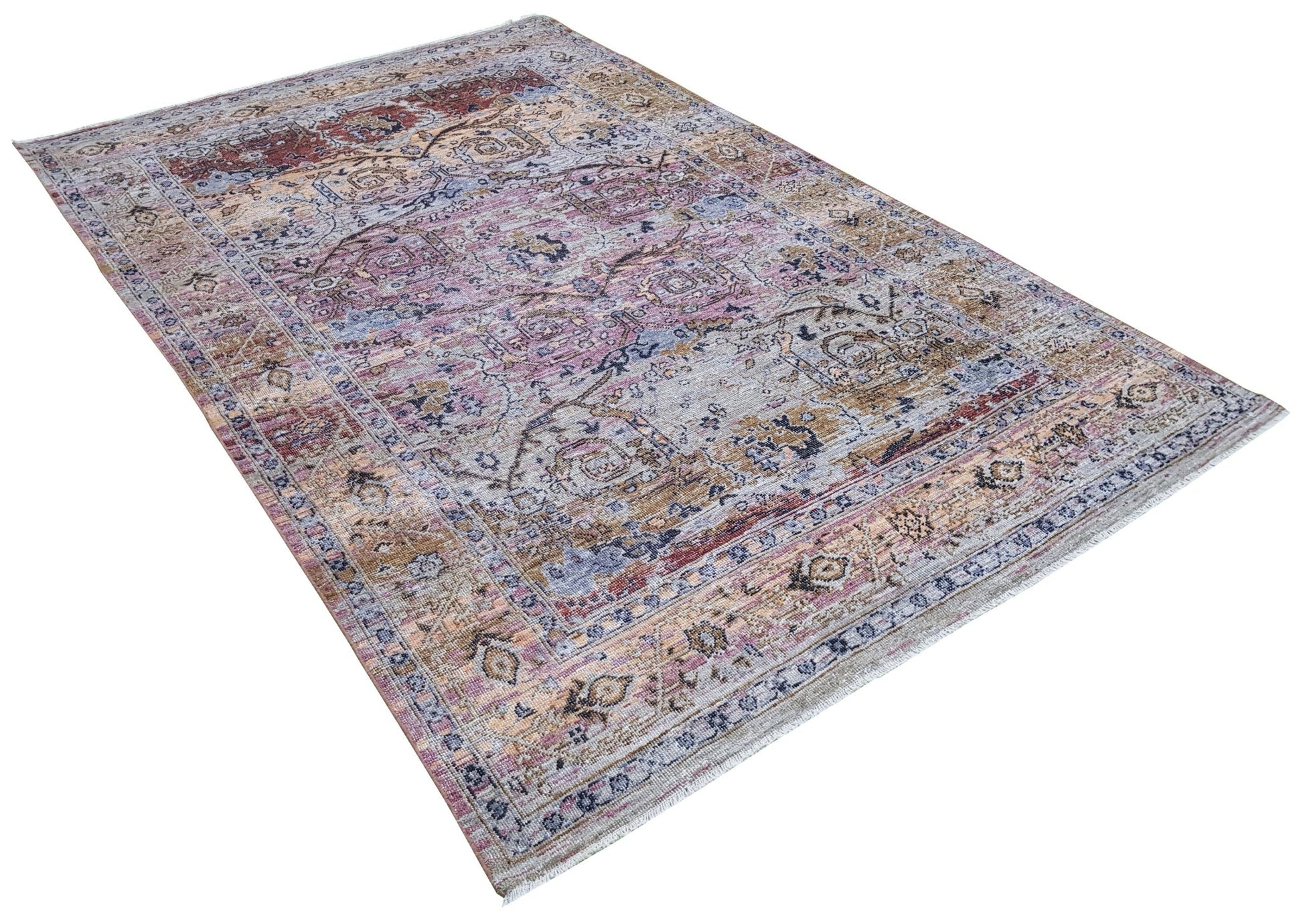 A transitional Oushak rug featuring a distressed pattern in muted tones of pink, blue, and tan.