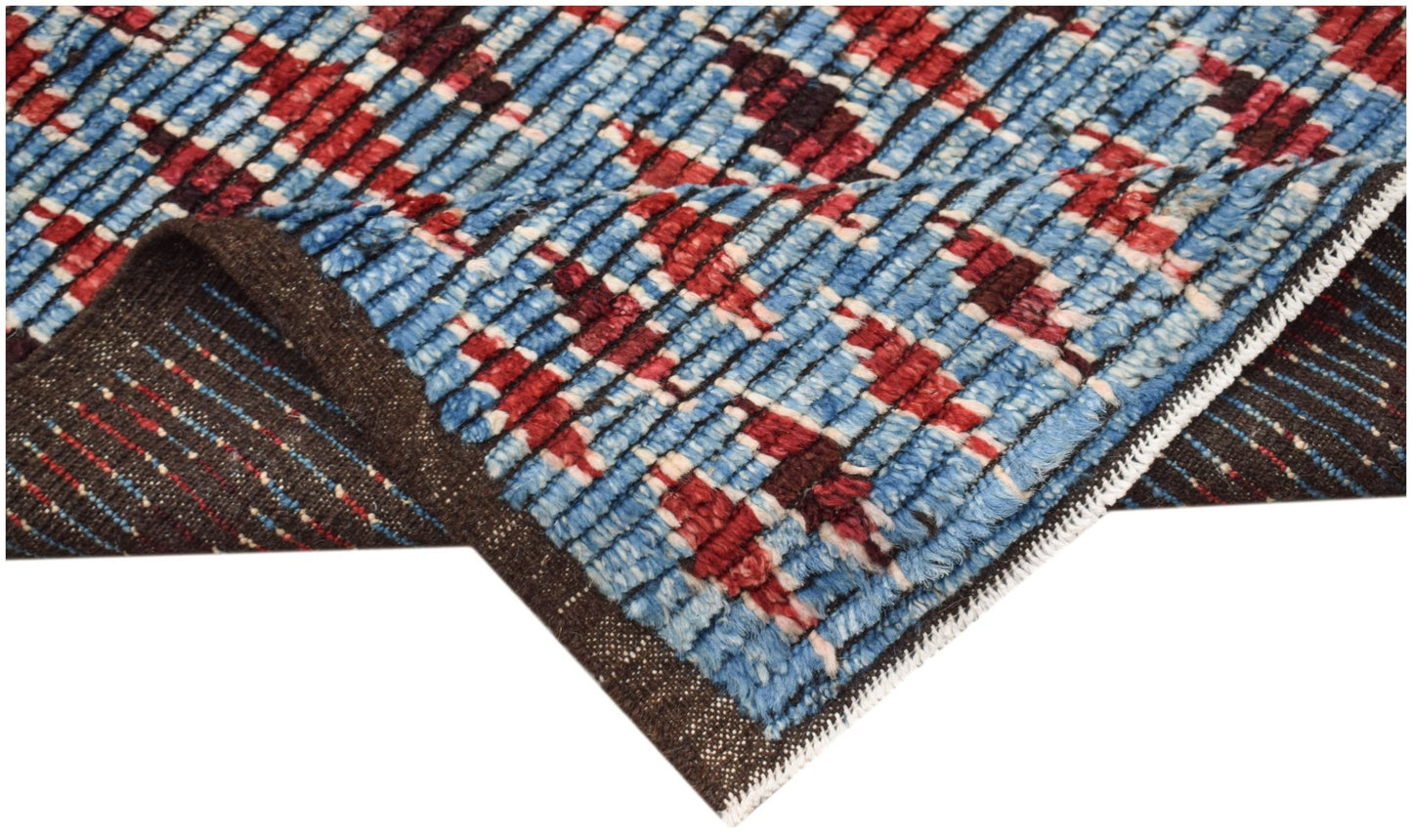 A hand-knotted Afghan Yekta rug featuring a geometric pattern in blue, red, and dark brown wool.