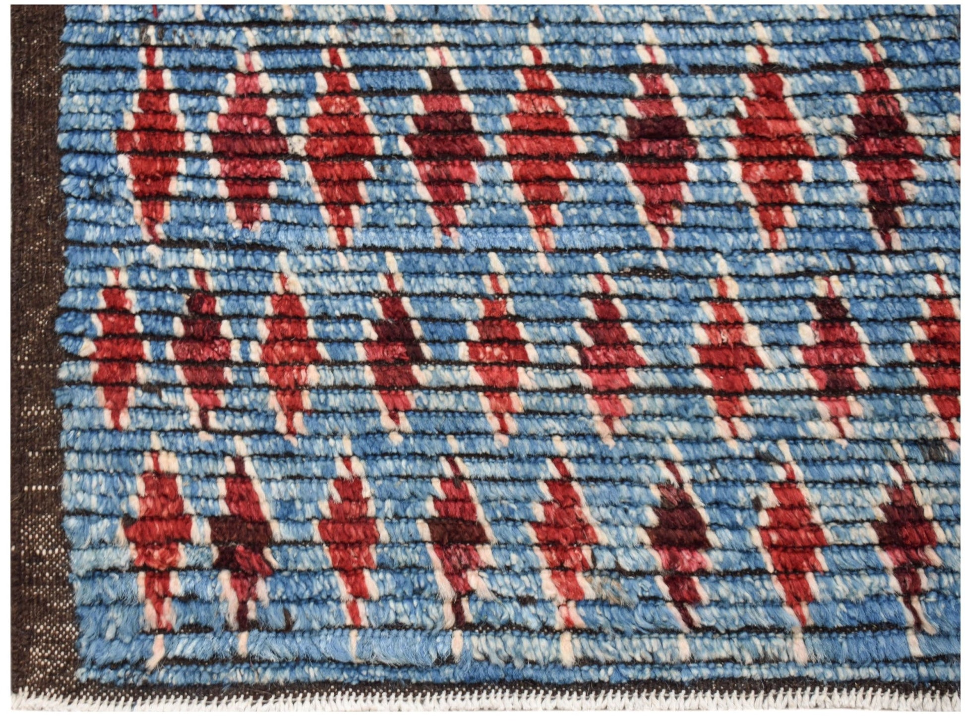 Hand-knotted Afghan rug featuring a blue field with repeating red geometric diamond patterns.