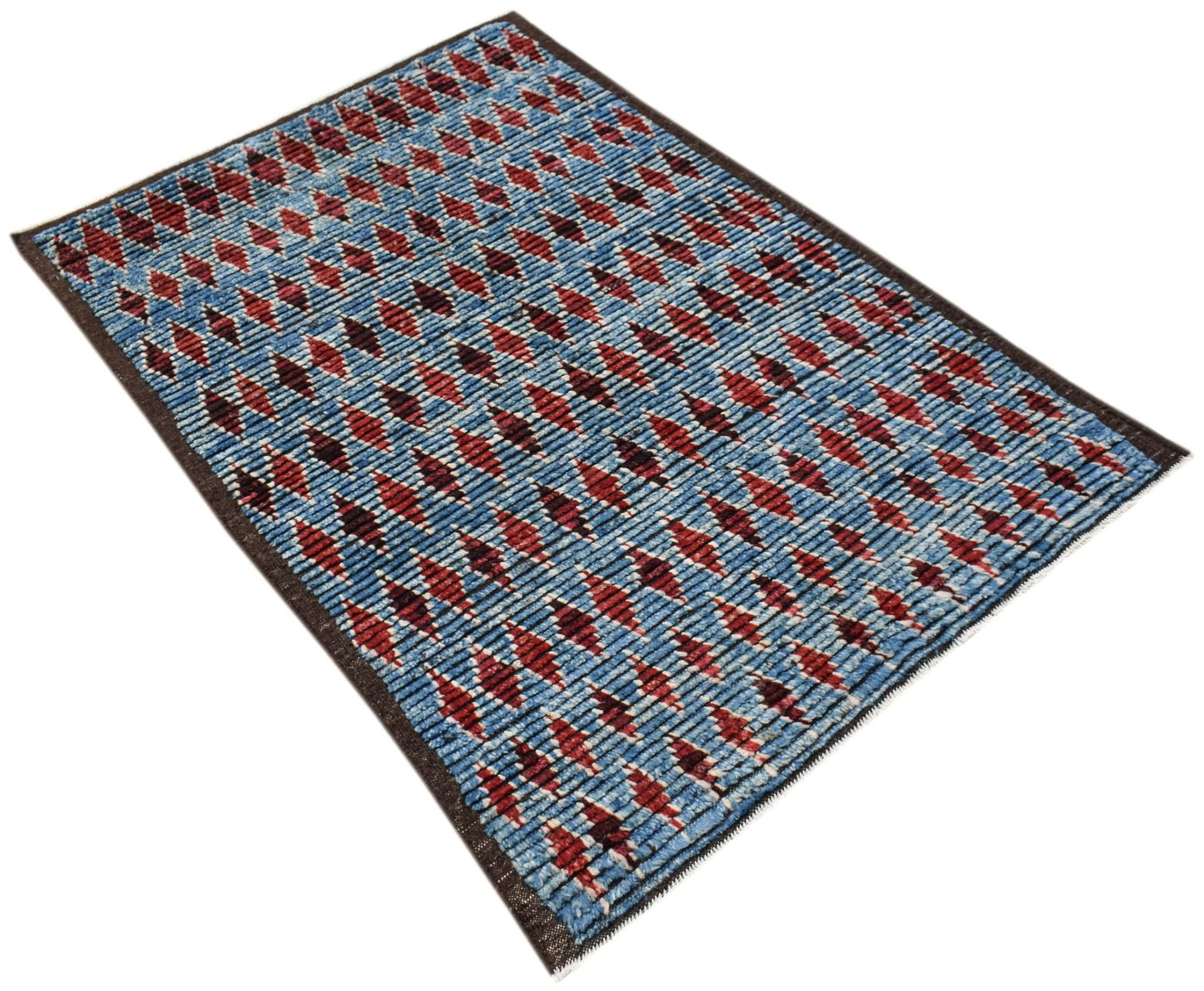 An Afghan Yekta rug featuring a blue field with repeating red and dark geometric diamond patterns.