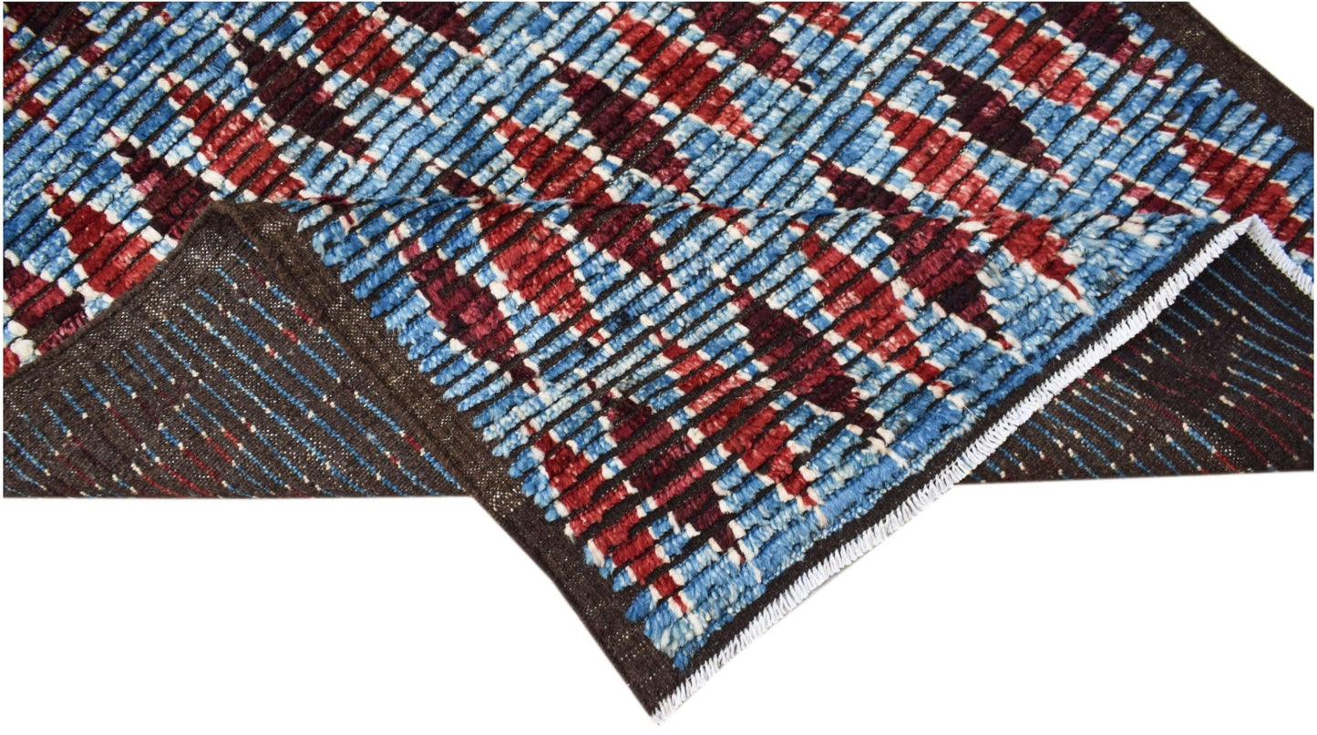 A hand-knotted Afghan Yekta rug featuring a geometric pattern in blue, red, and dark brown wool.