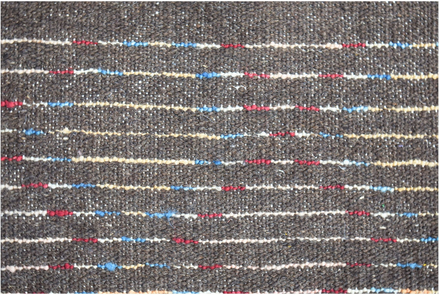 A dark brown hand-knotted Afghan wool rug featuring horizontal stripes of red, blue, and cream.