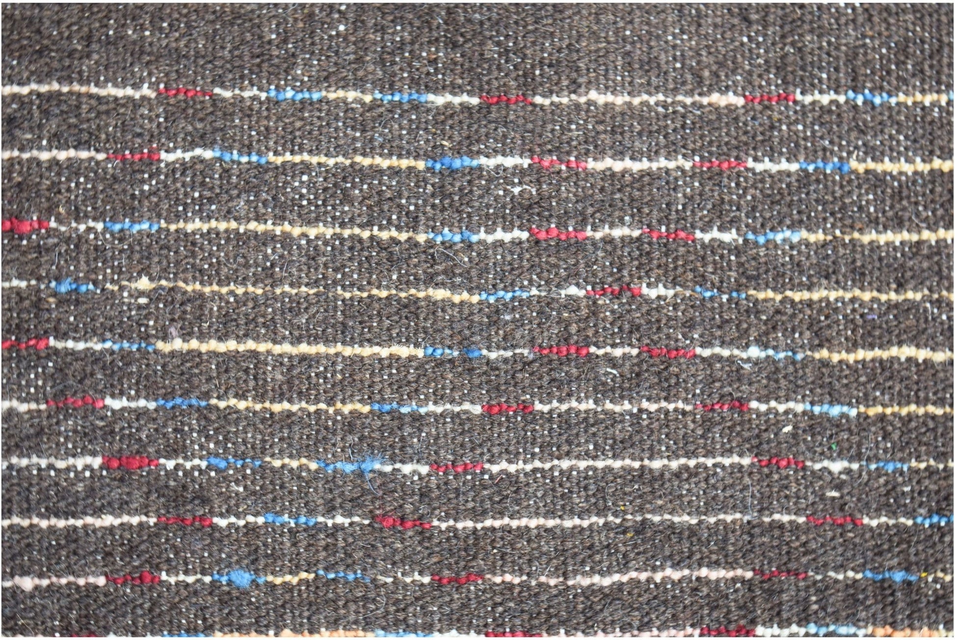 A dark brown hand-knotted Afghan wool rug featuring horizontal stripes of red, blue, and cream.