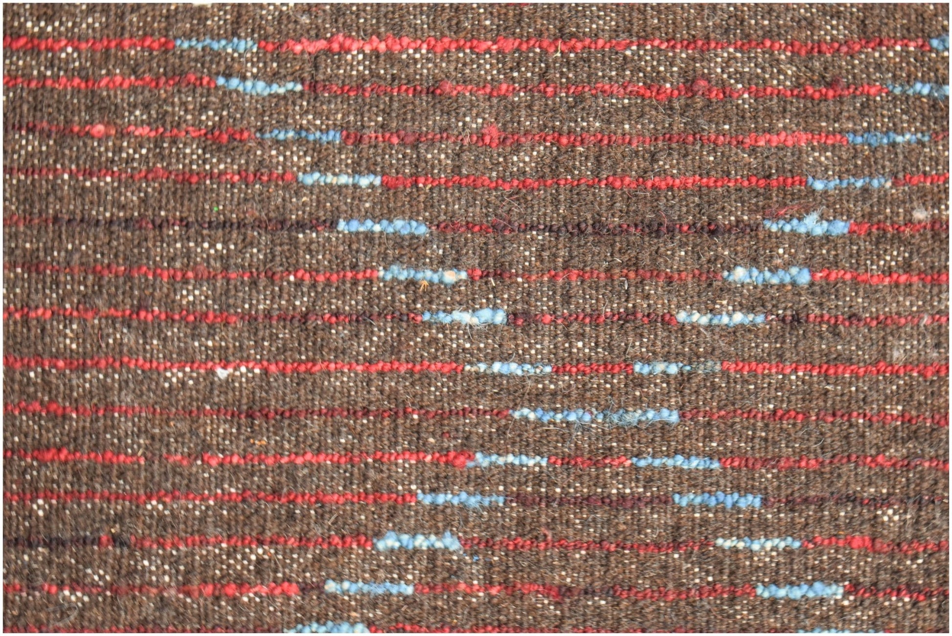 A brown hand-knotted Afghan wool rug featuring horizontal red and blue striped accents.