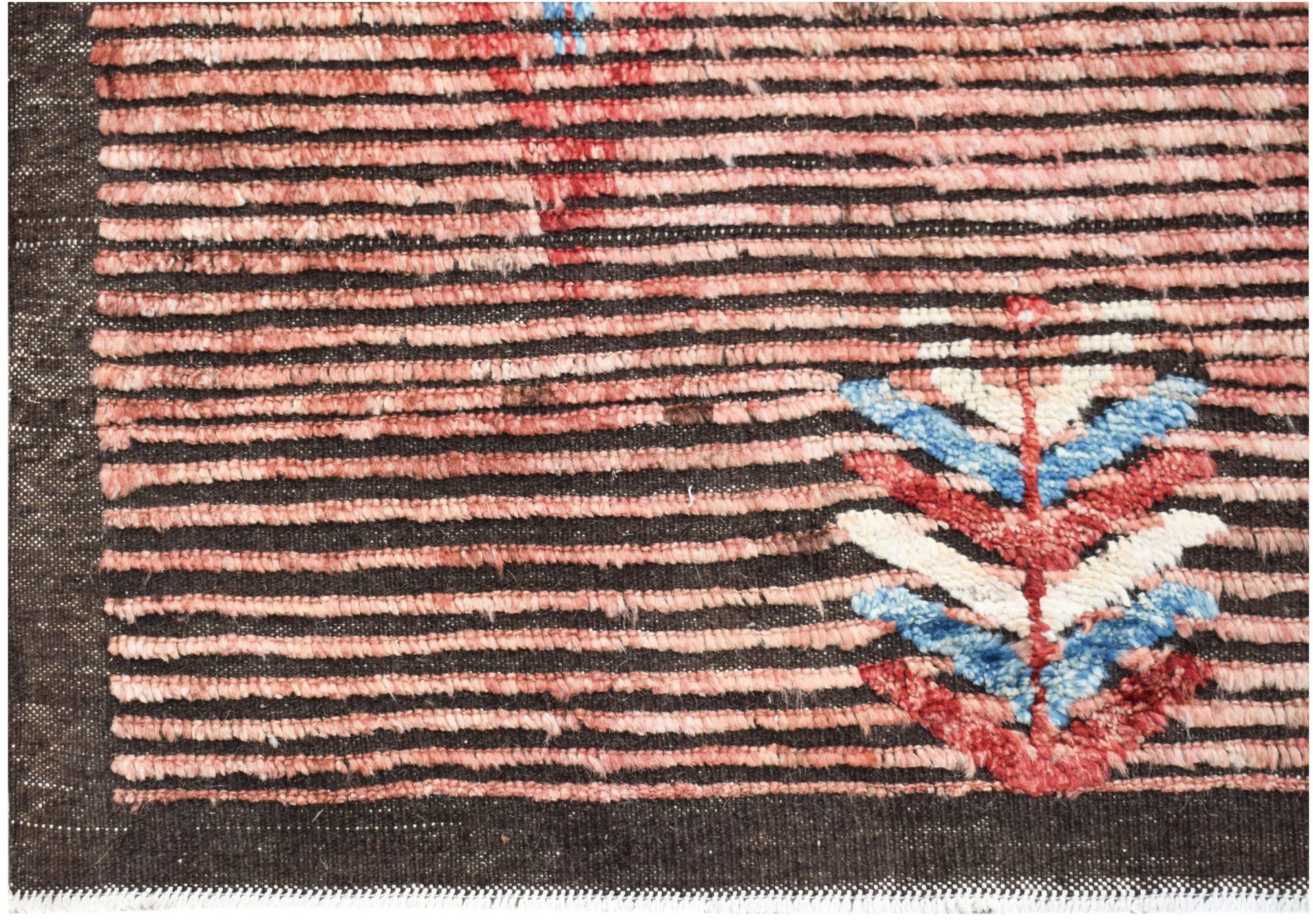 Hand-knotted Afghan rug with horizontal pink stripes and a colorful geometric leaf motif.