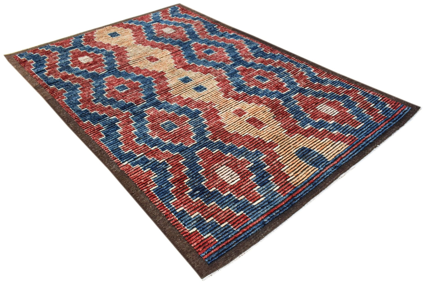 An Afghan Yekta rug featuring a bold geometric pattern in red, blue, and cream wool.