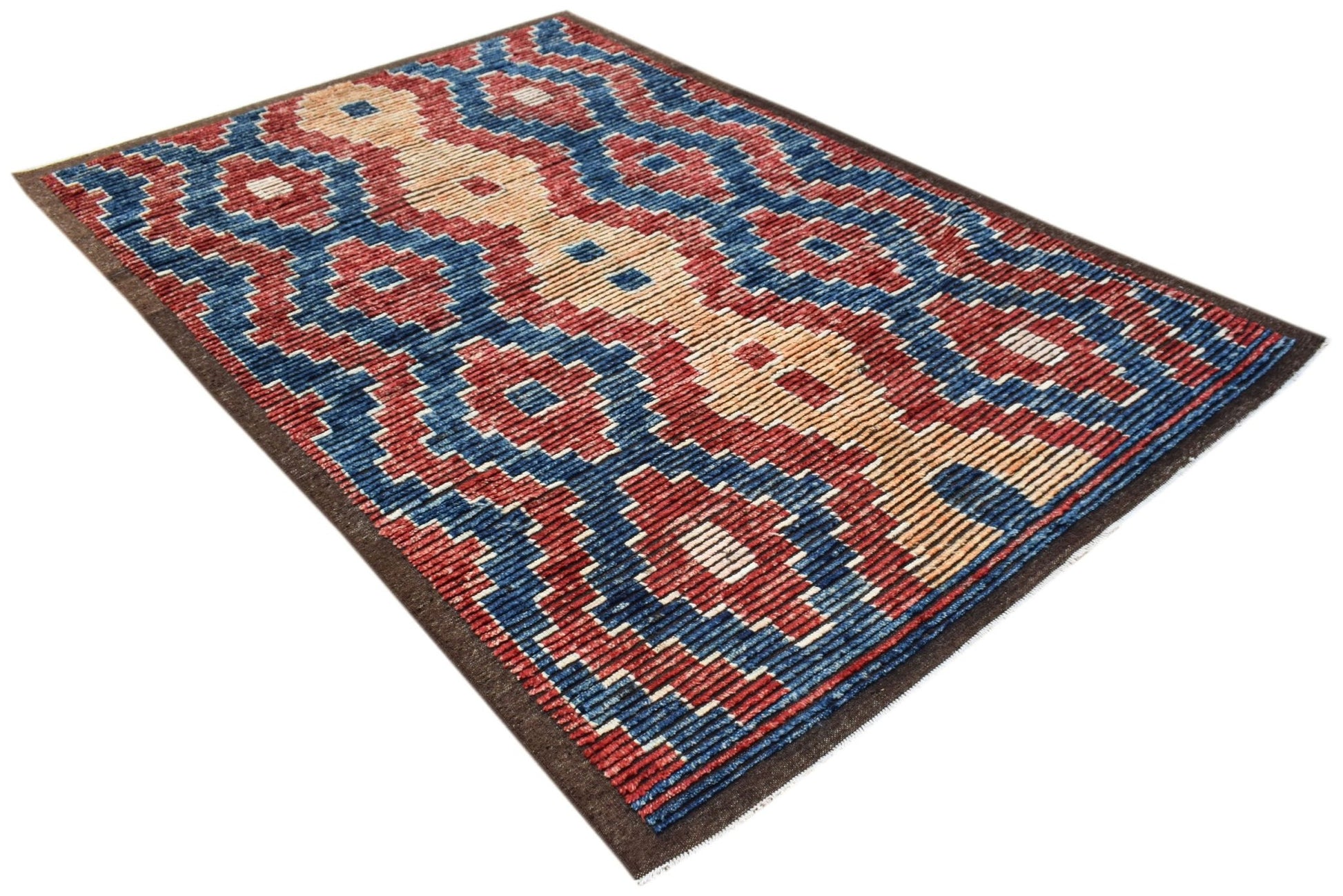 An Afghan Yekta rug featuring a bold geometric pattern in red, blue, and cream wool.