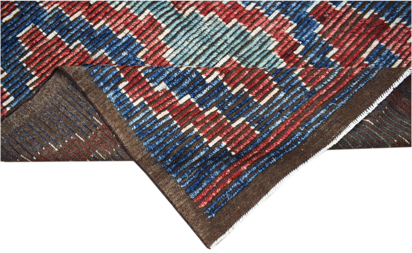 A hand-knotted Afghan rug featuring a geometric pattern in red, blue, and white wool.