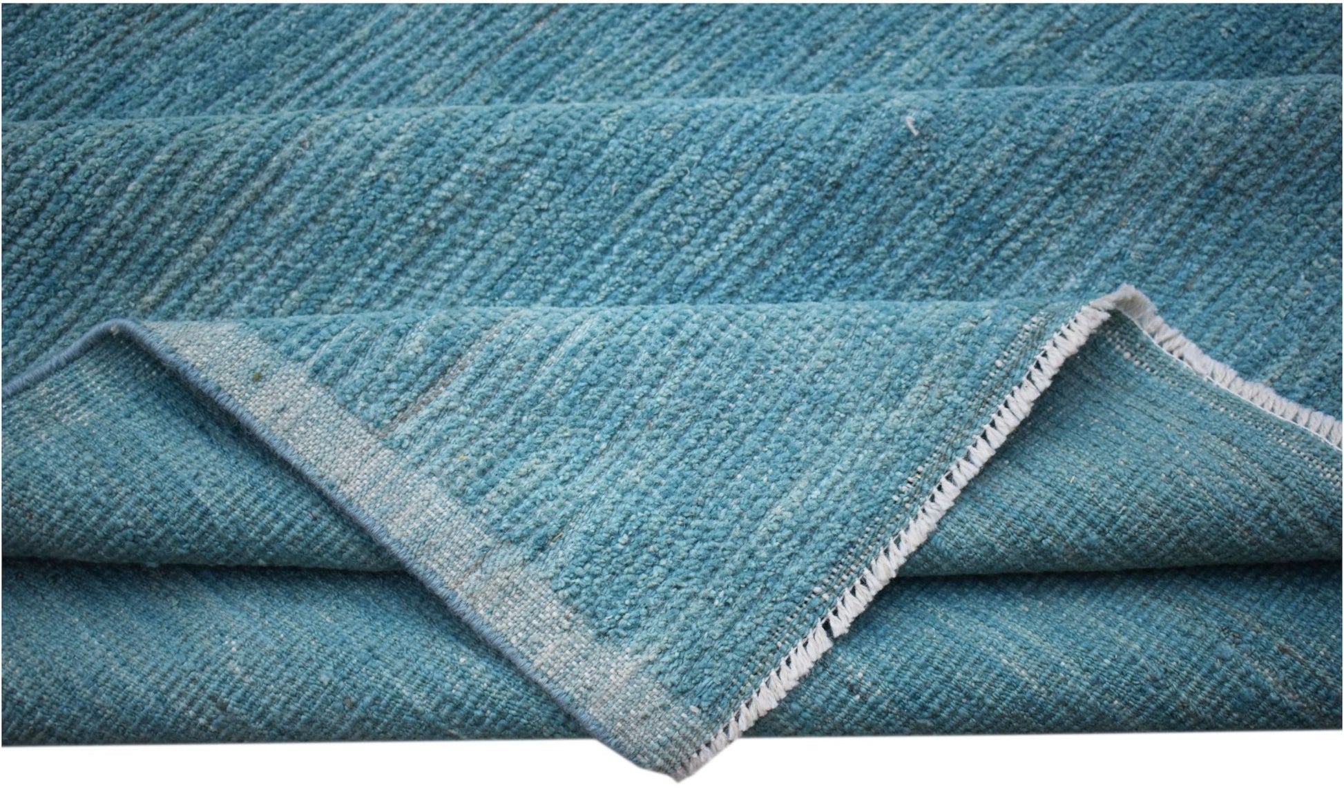 A hand-knotted Afghan Kohi rug in a solid blue tone with a textured wool pile.