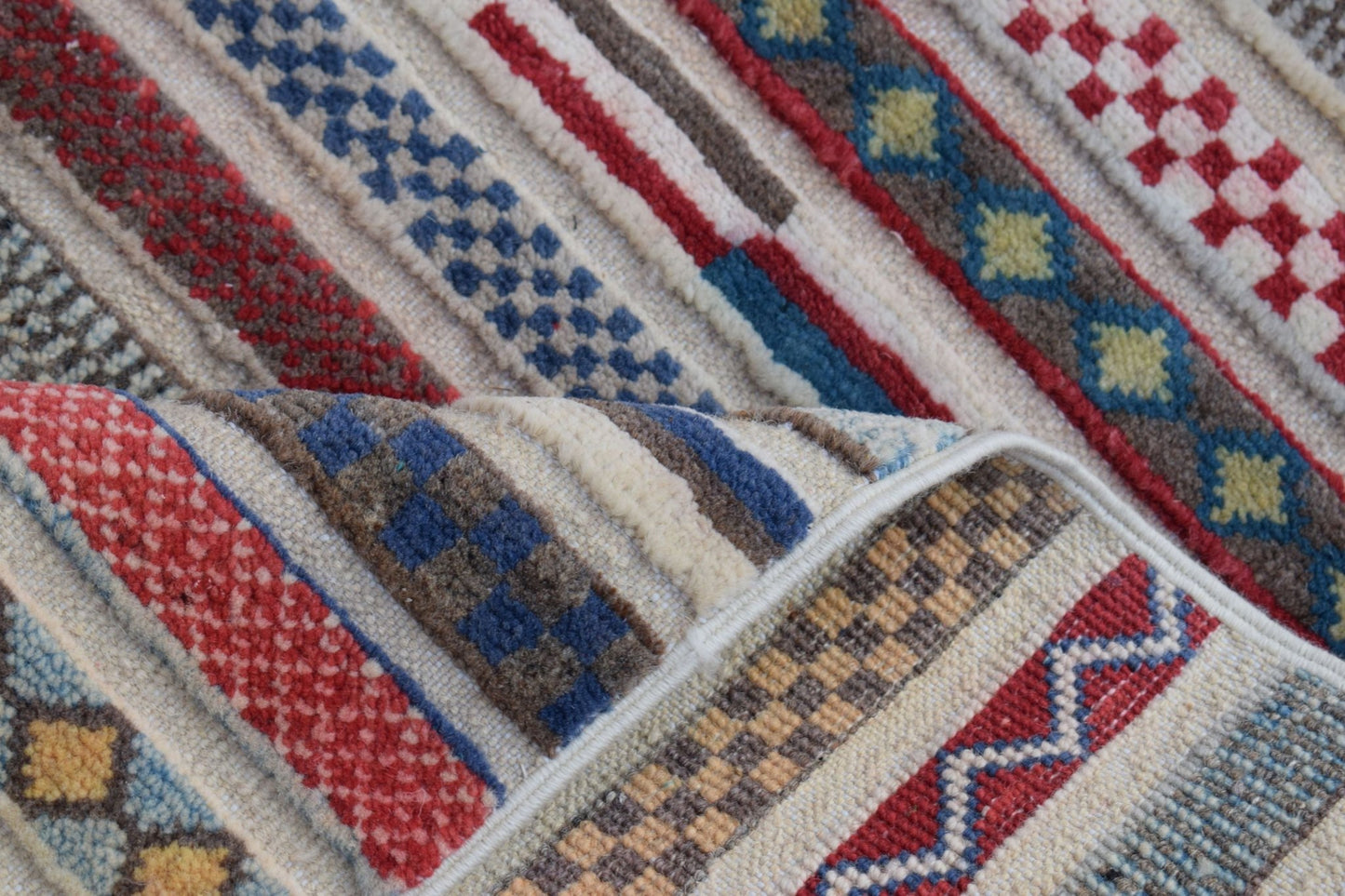 A handmade Afghan Yekta runner featuring a colorful geometric pattern of stripes and checkered motifs.