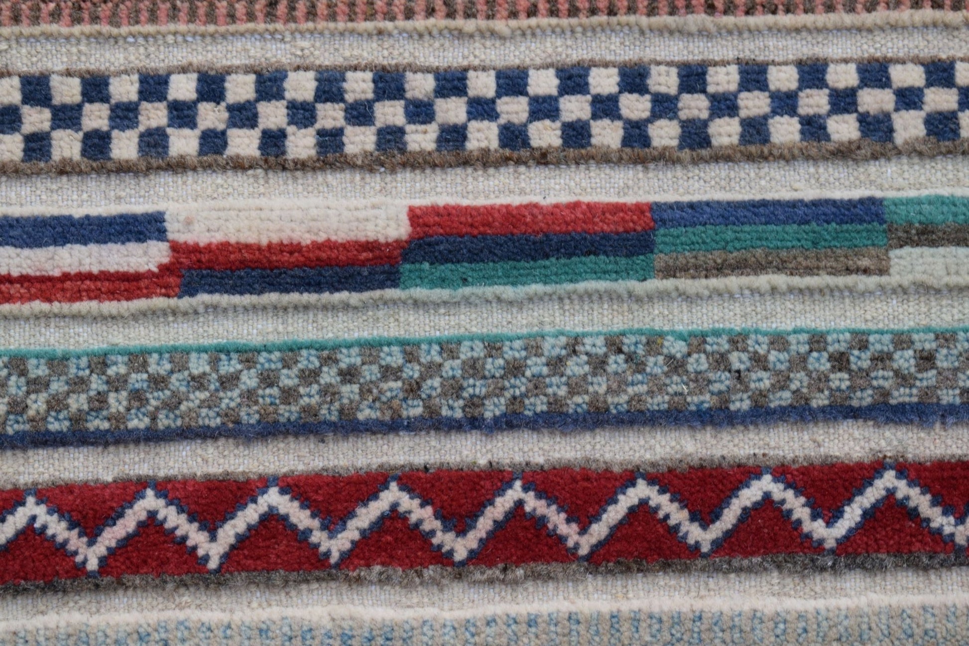 A handmade Afghan Yekta runner featuring horizontal bands of geometric patterns in wool.