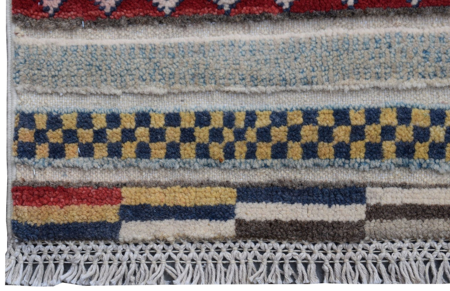 A handmade Afghan Yekta runner featuring geometric patterns in red, blue, yellow, and cream wool.