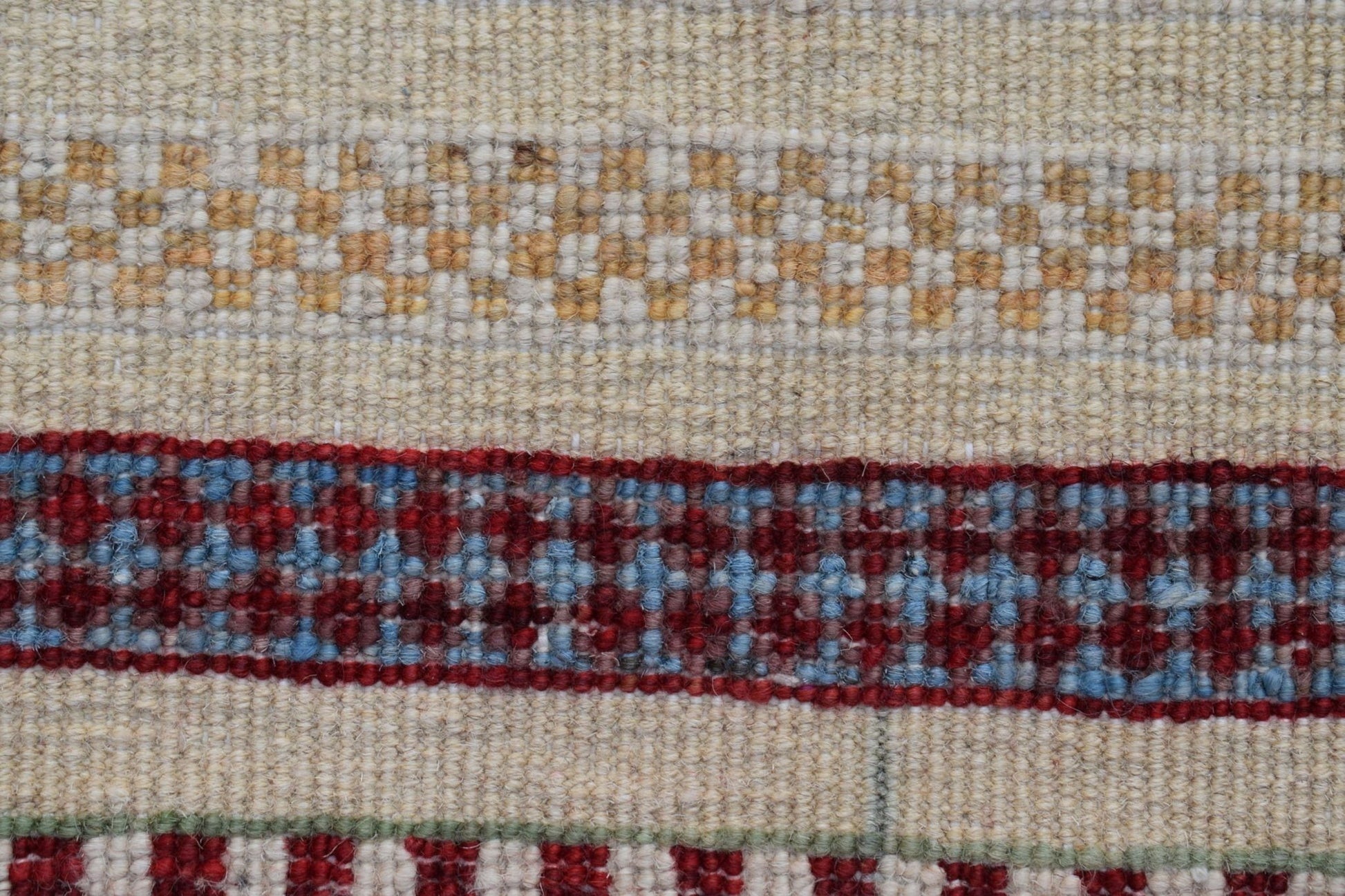 A close-up of an Afghan Yekta runner featuring horizontal bands of cream, gold, and red patterns.