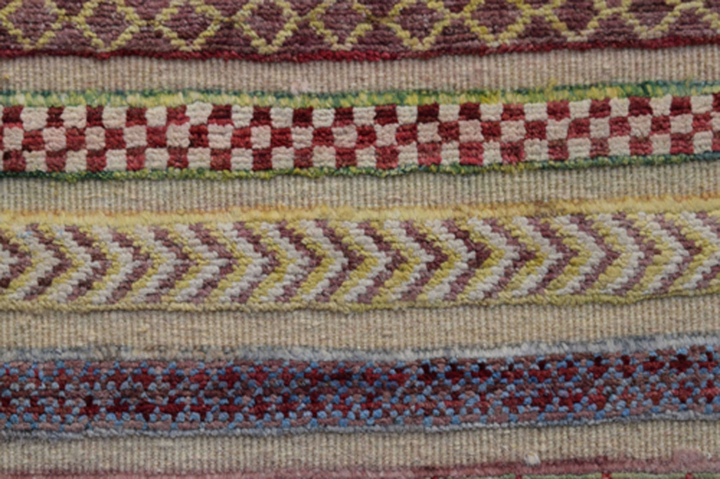 A handmade Afghan Yekta runner featuring horizontal bands of geometric and checkered patterns.