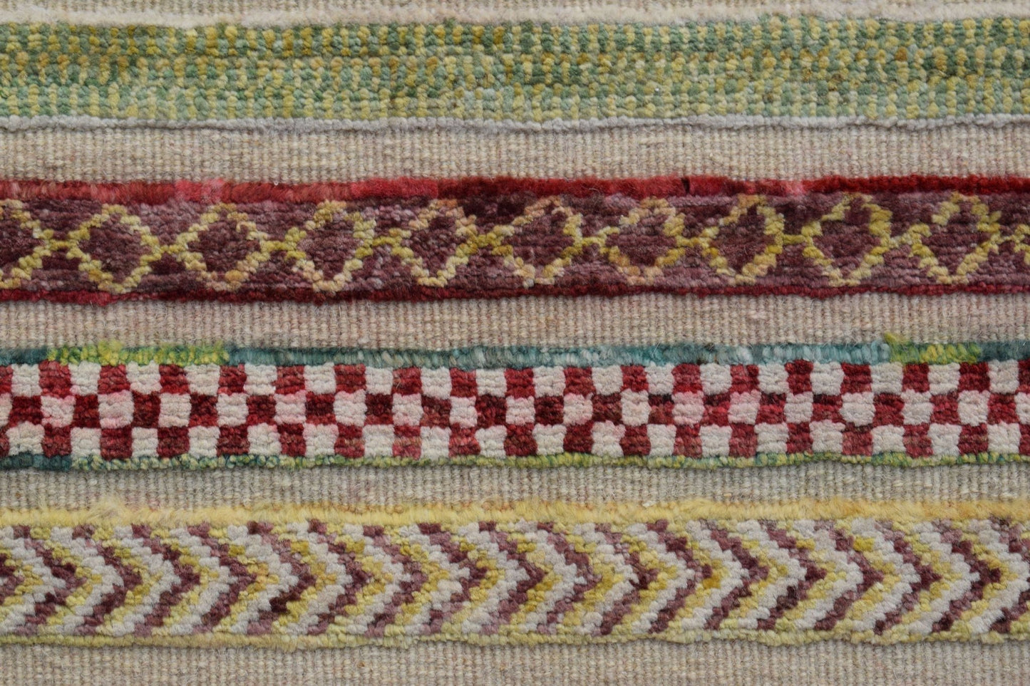 A close-up of an Afghan Yekta runner featuring horizontal bands of geometric and checkered patterns.