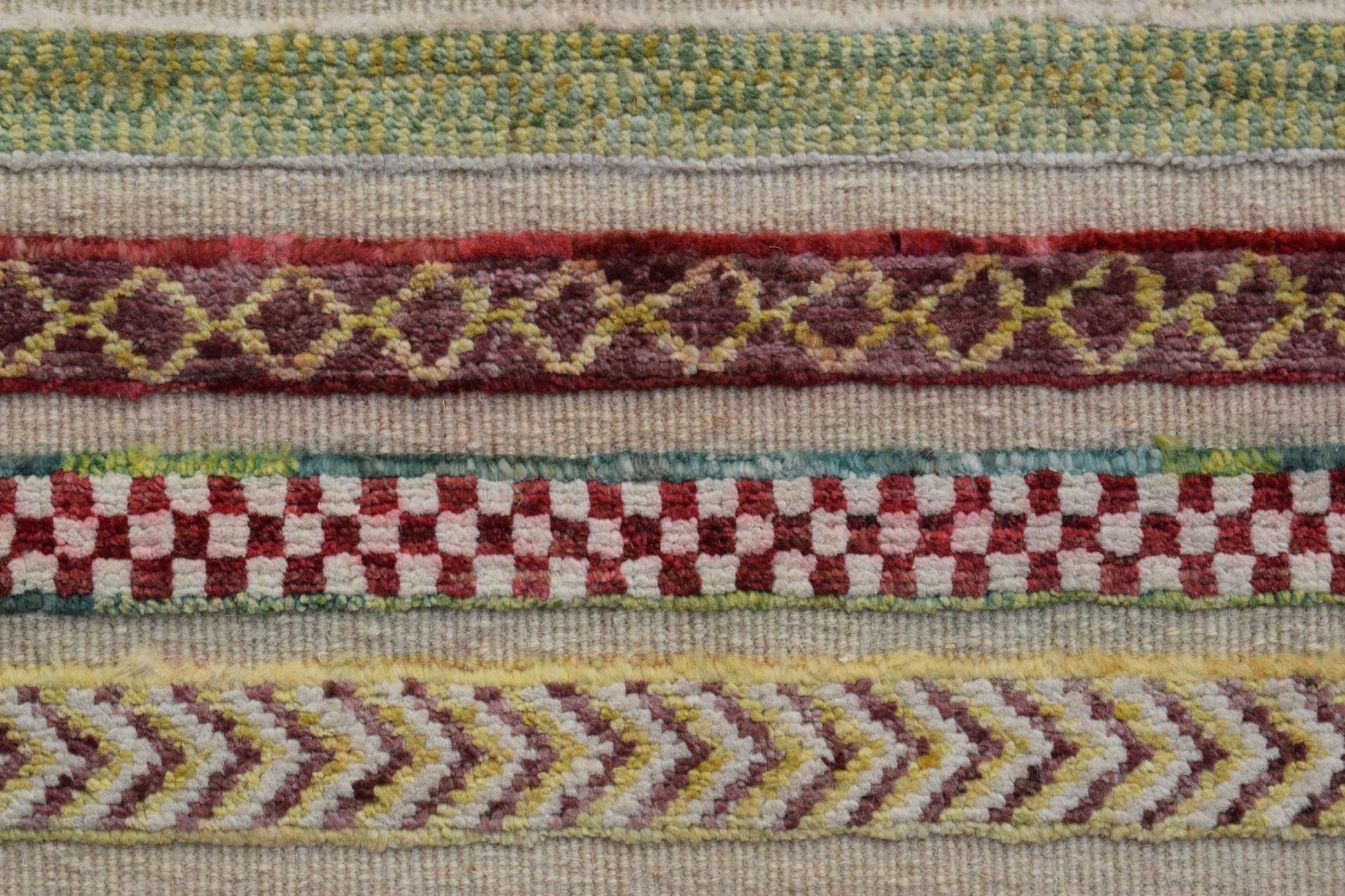 A close-up of an Afghan Yekta runner featuring horizontal bands of geometric and checkered patterns.