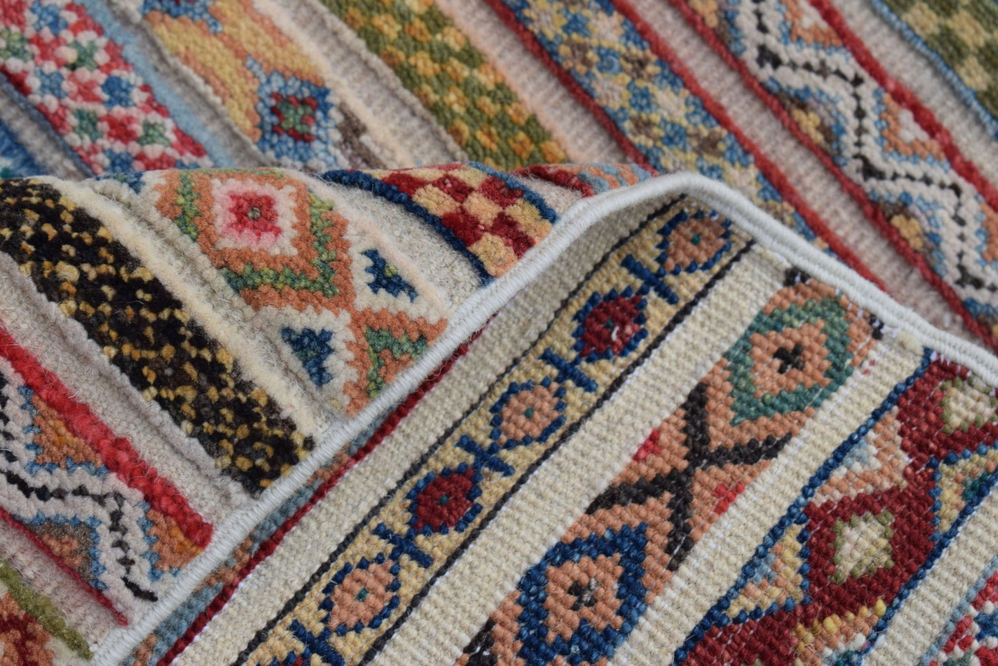 A close-up of a handmade Afghan Yekta runner featuring intricate geometric patterns in wool.