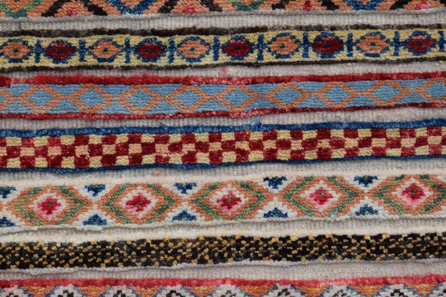 A close-up of an Afghan Yekta runner featuring horizontal bands of intricate geometric patterns.