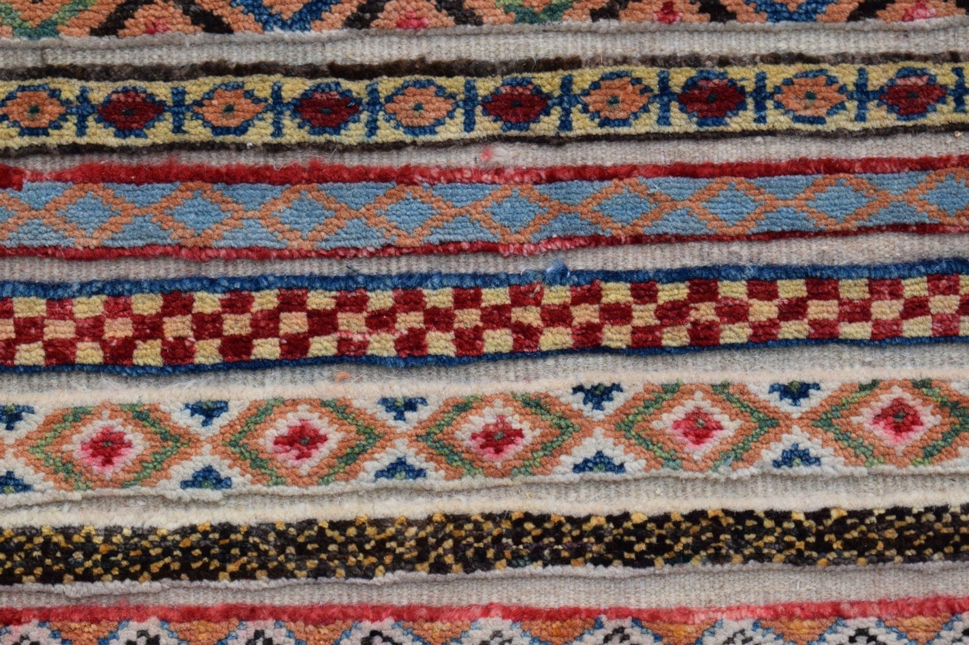 A close-up of an Afghan Yekta runner featuring horizontal bands of intricate geometric patterns.