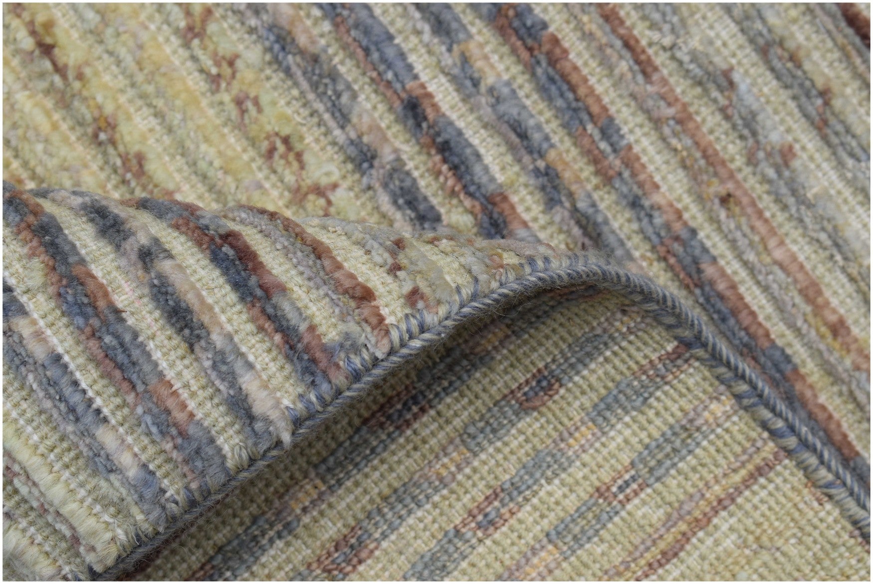 A handmade Afghan Yekta rug featuring a textured, striped pattern in muted earth tones.