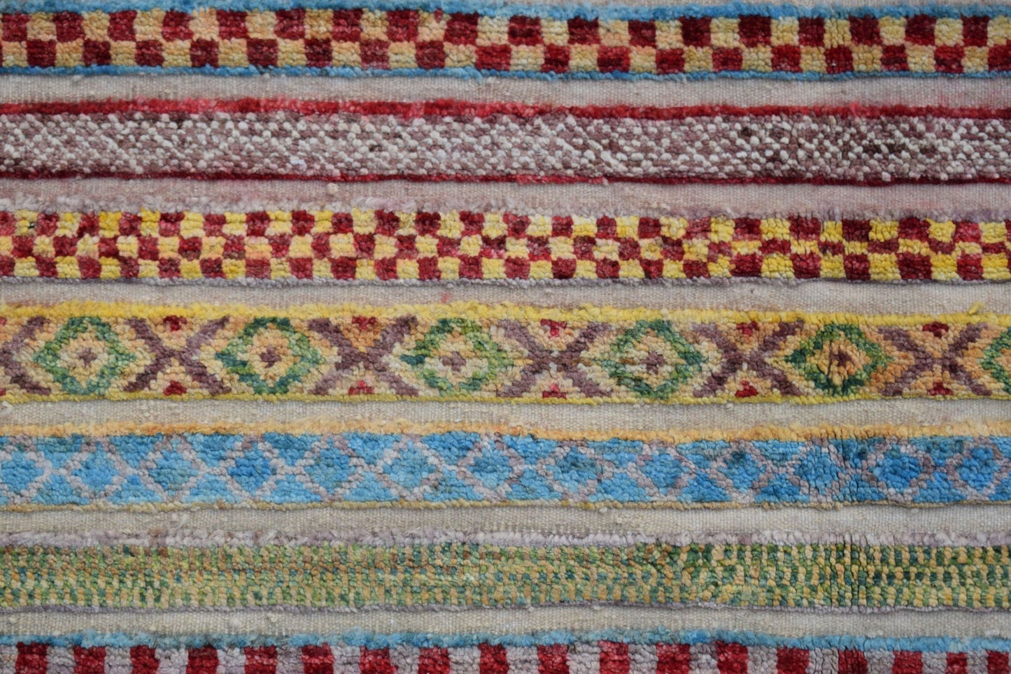 A handmade Afghan Yekta rug featuring horizontal bands of colorful geometric and checkered patterns.