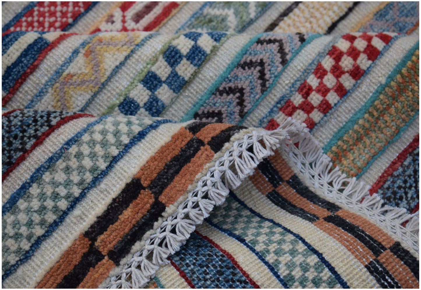 A handmade Afghan Yekta rug featuring a colorful geometric striped pattern and fringed edges.