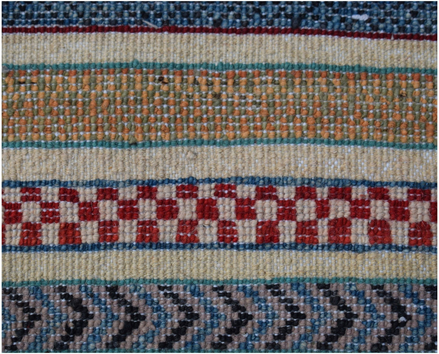 A close-up of an Afghan Yekta rug featuring horizontal bands of geometric patterns in wool.