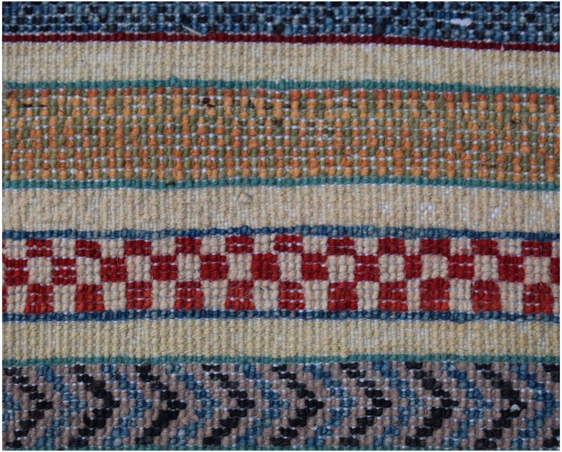 A close-up of an Afghan Yekta rug featuring horizontal bands of geometric patterns in wool.