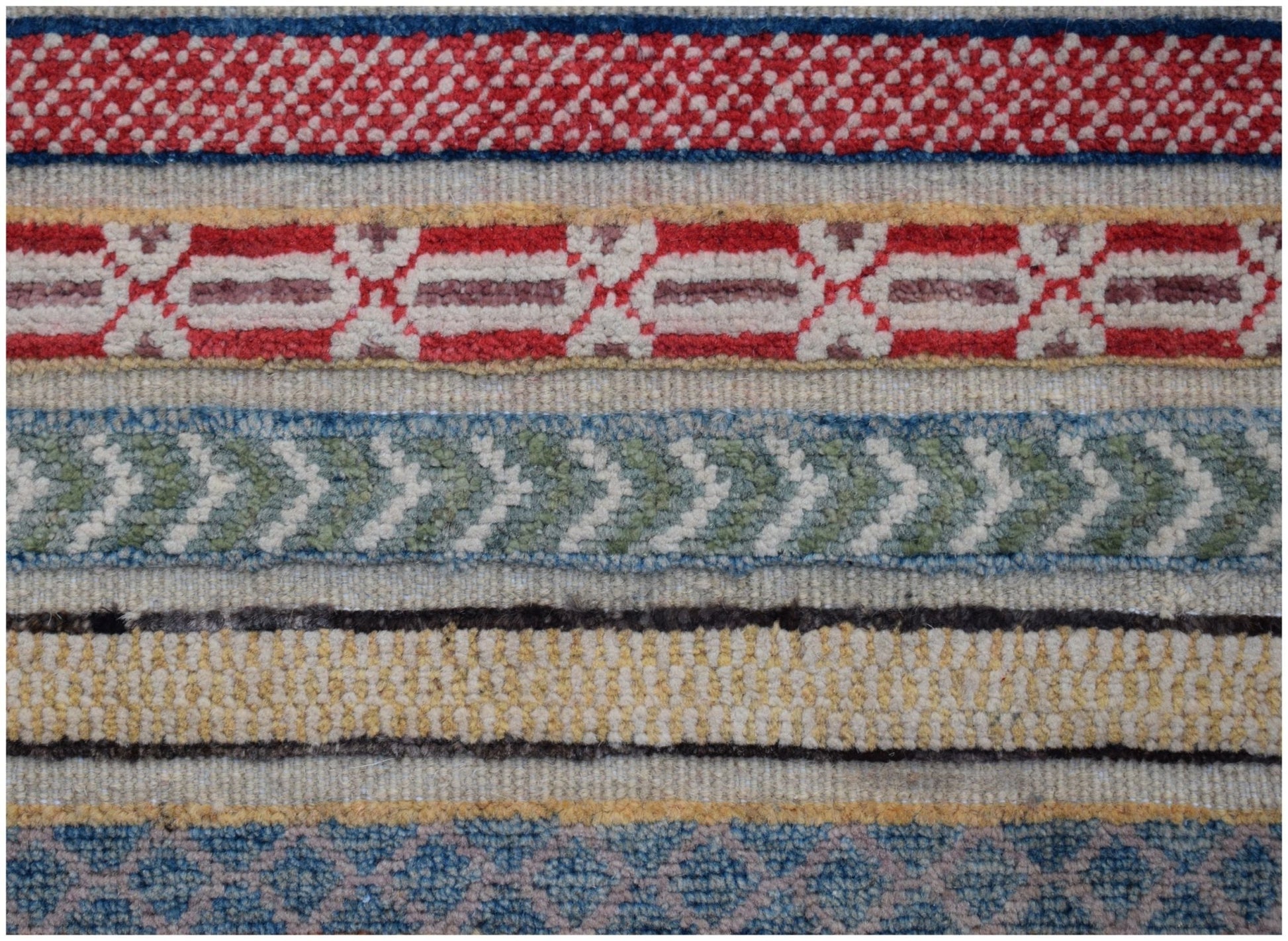 A close-up of an Afghan Yekta rug featuring horizontal bands of intricate geometric patterns.