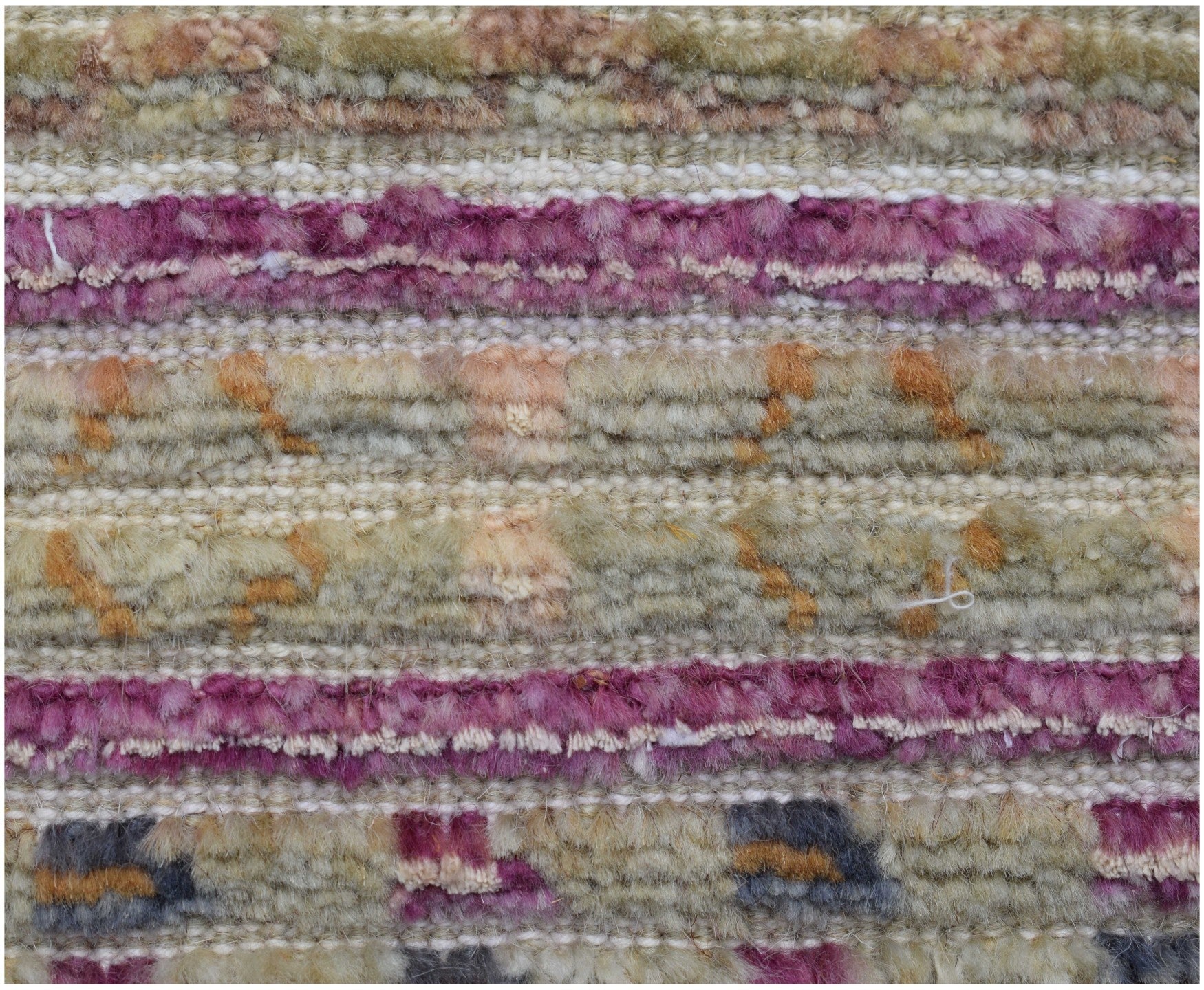 A close-up of a handmade Afghan rug featuring horizontal stripes of textured wool in purple and tan.