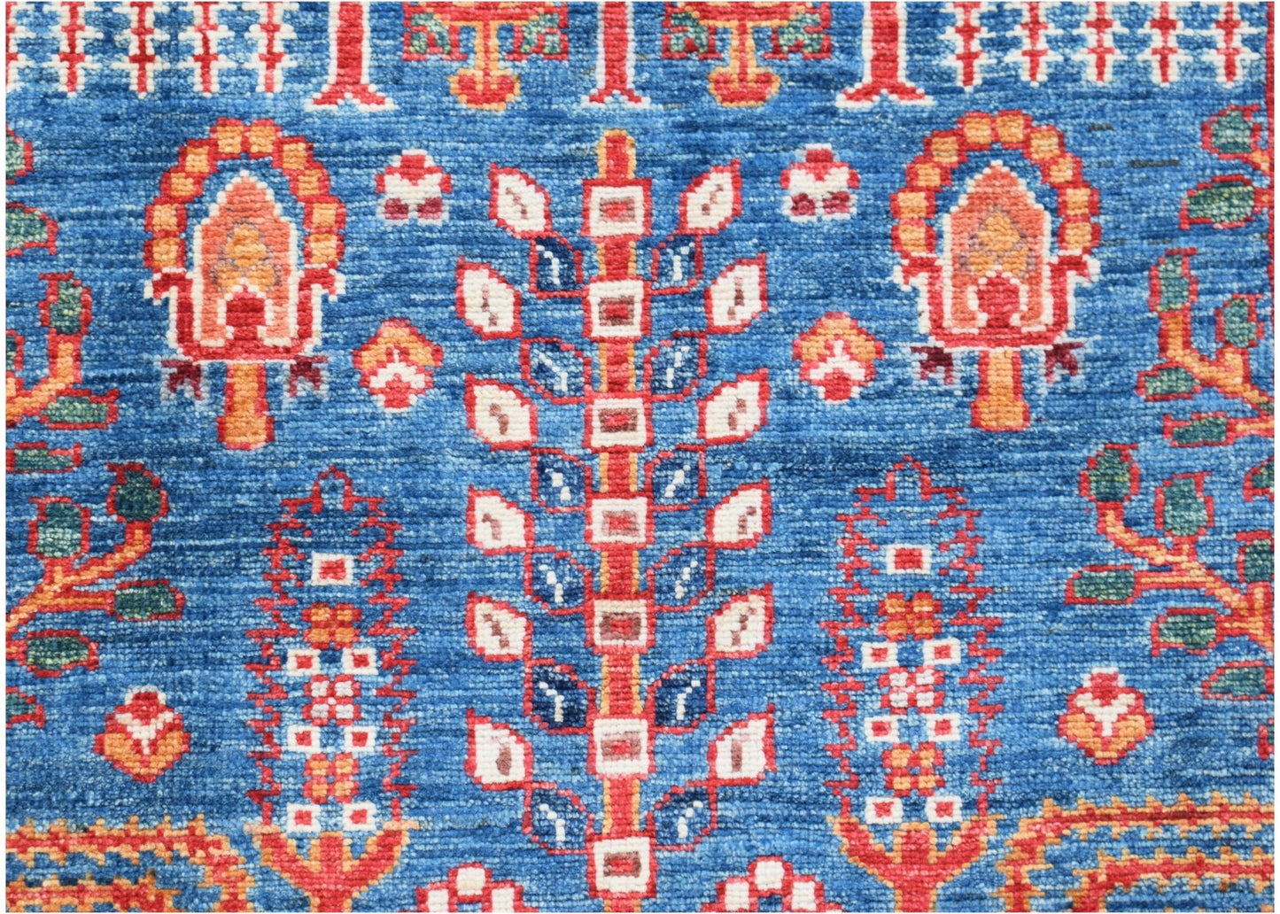 A handwoven Afghan Chobi runner featuring a traditional tree motif in red and blue wool.