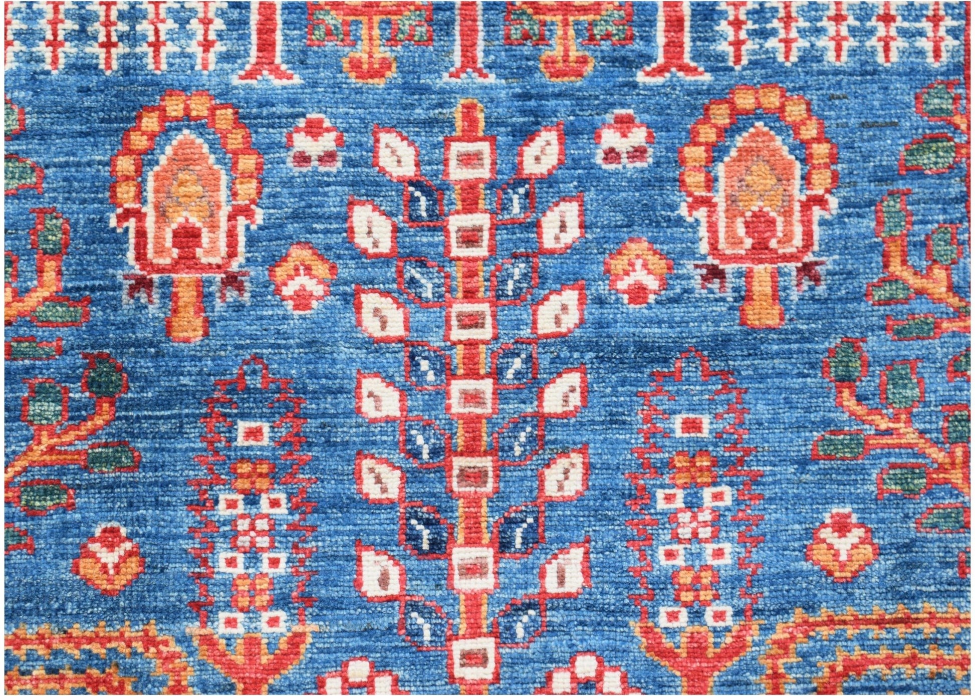 A handwoven Afghan Chobi runner featuring a traditional tree motif in red and blue wool.