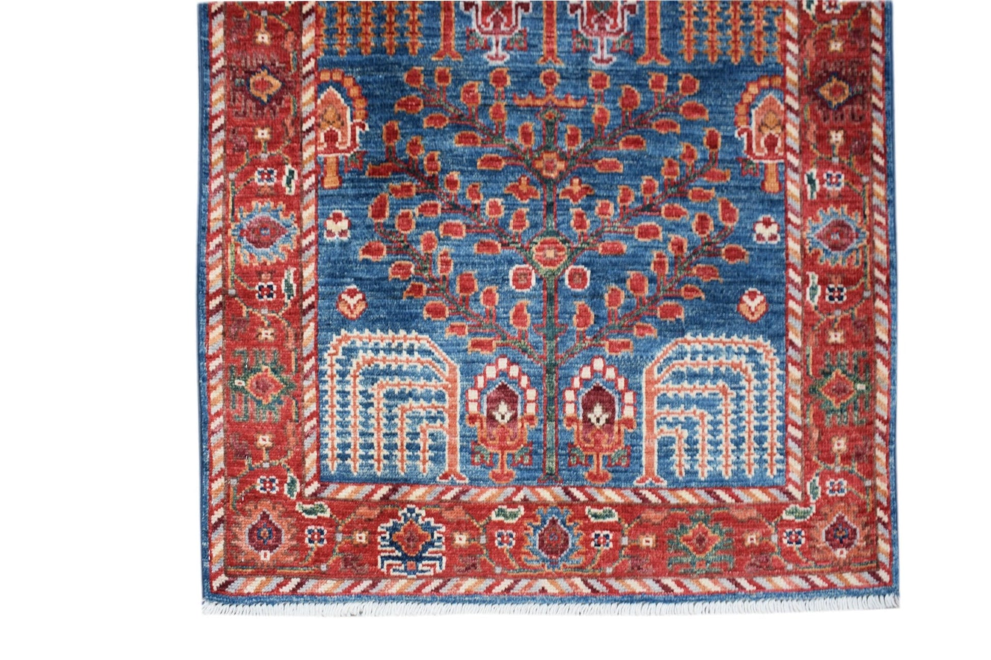 Handwoven Afghan Chobi runner featuring a tree of life motif in red and blue wool.