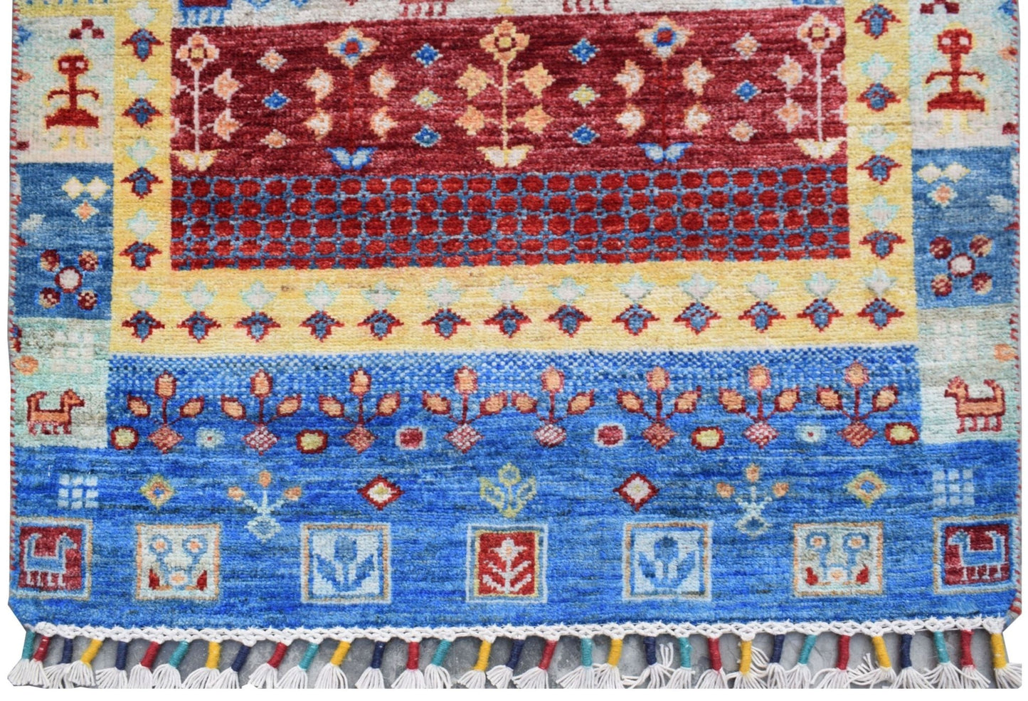 A handmade Afghan Chobi runner featuring a vibrant geometric and floral pattern in blue, red, and yellow.