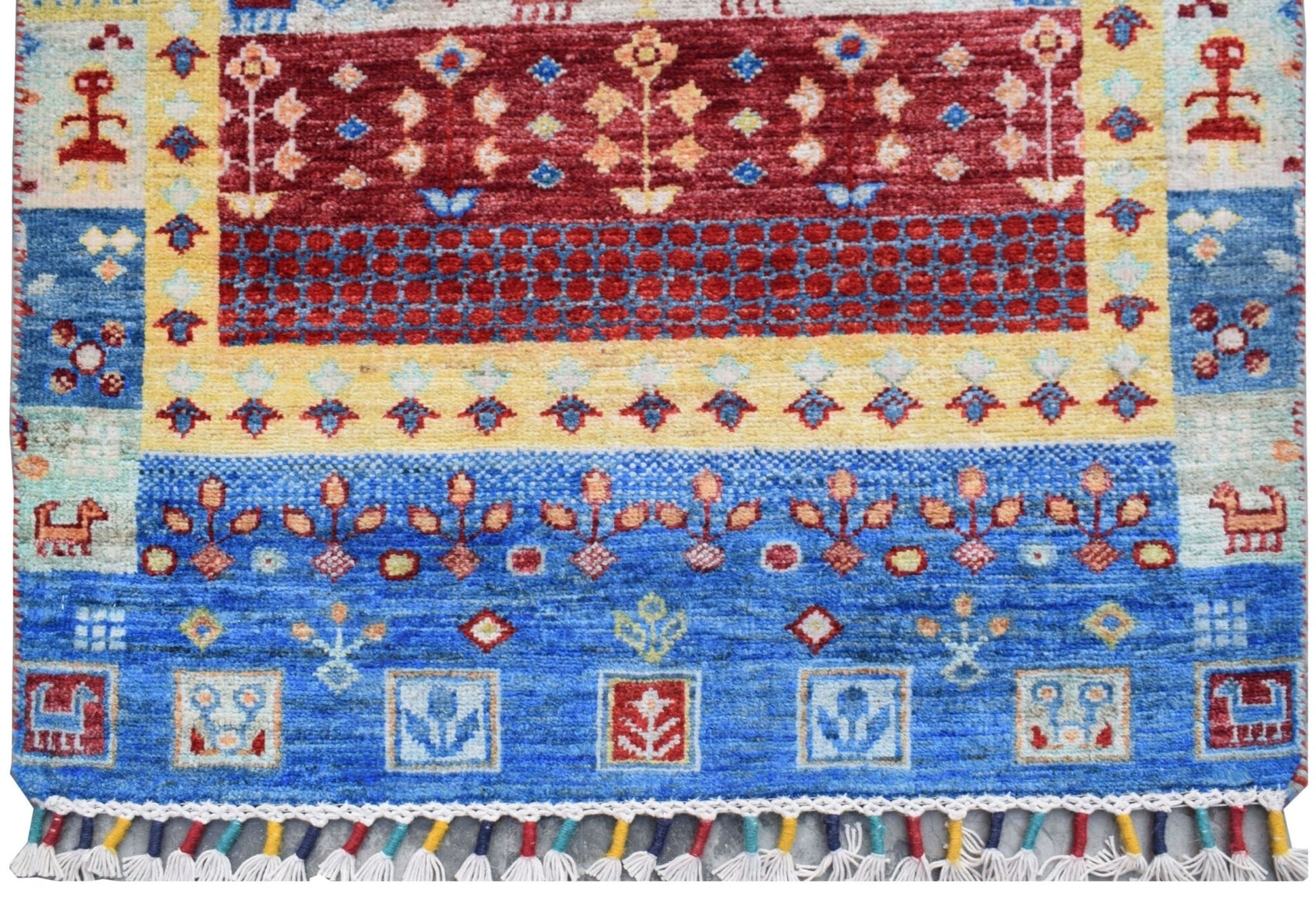 A handmade Afghan Chobi runner featuring a vibrant geometric and floral pattern in blue, red, and yellow.