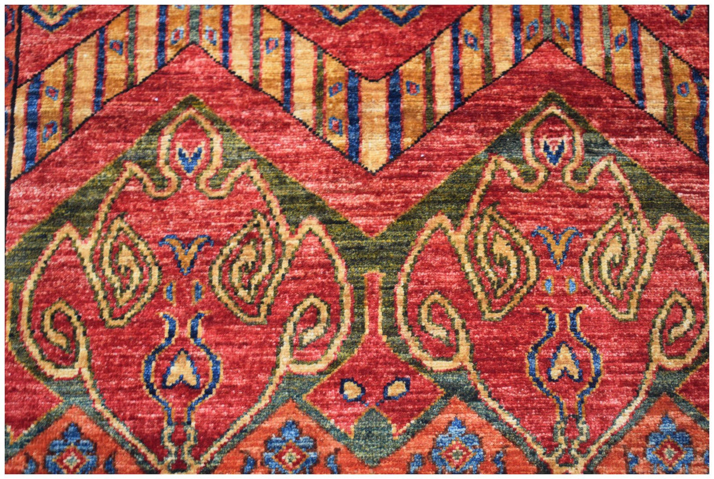 A handmade Afghan Chobi runner featuring intricate traditional patterns in red, green, and gold.