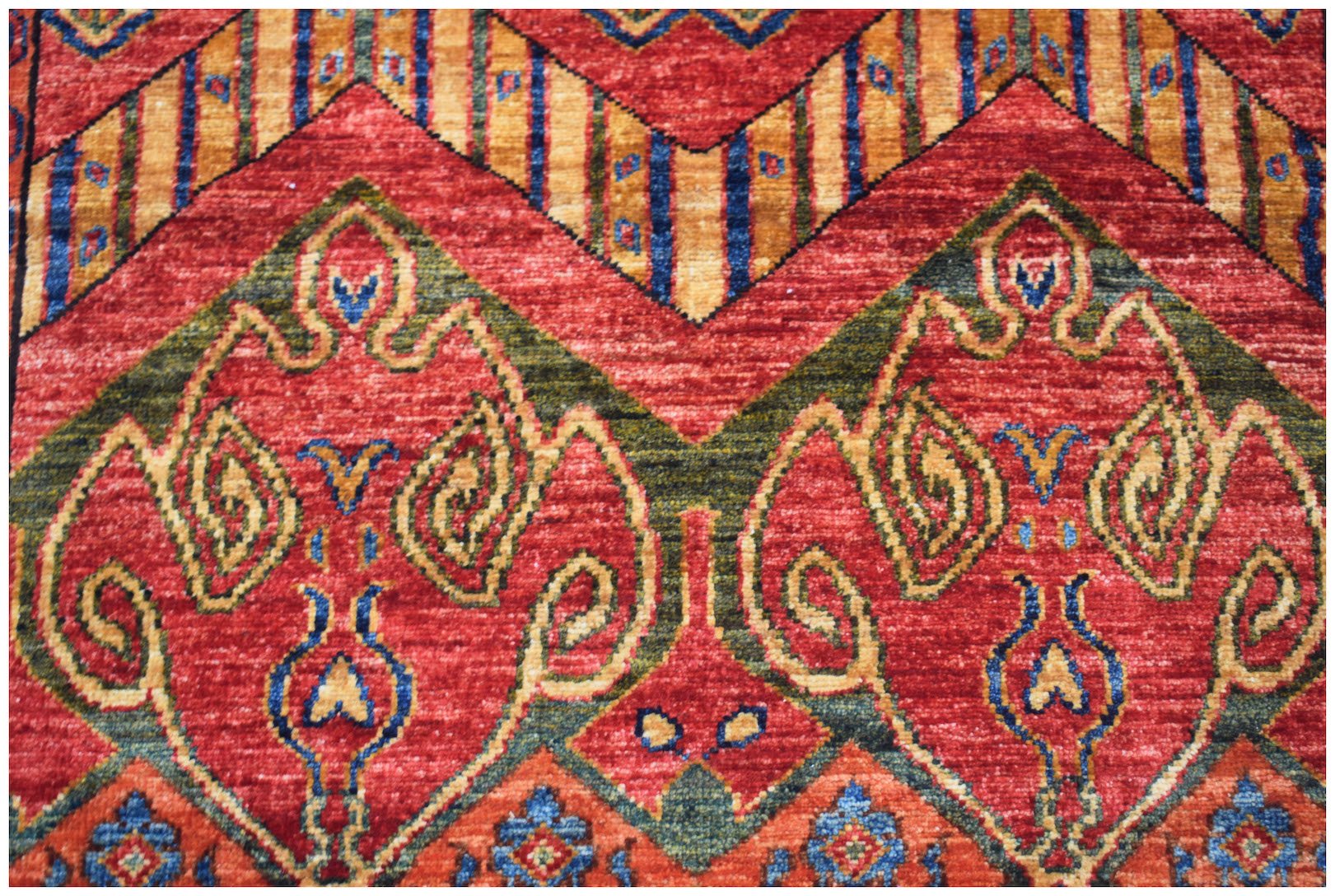 A handmade Afghan Chobi runner featuring intricate traditional patterns in red, green, and gold.